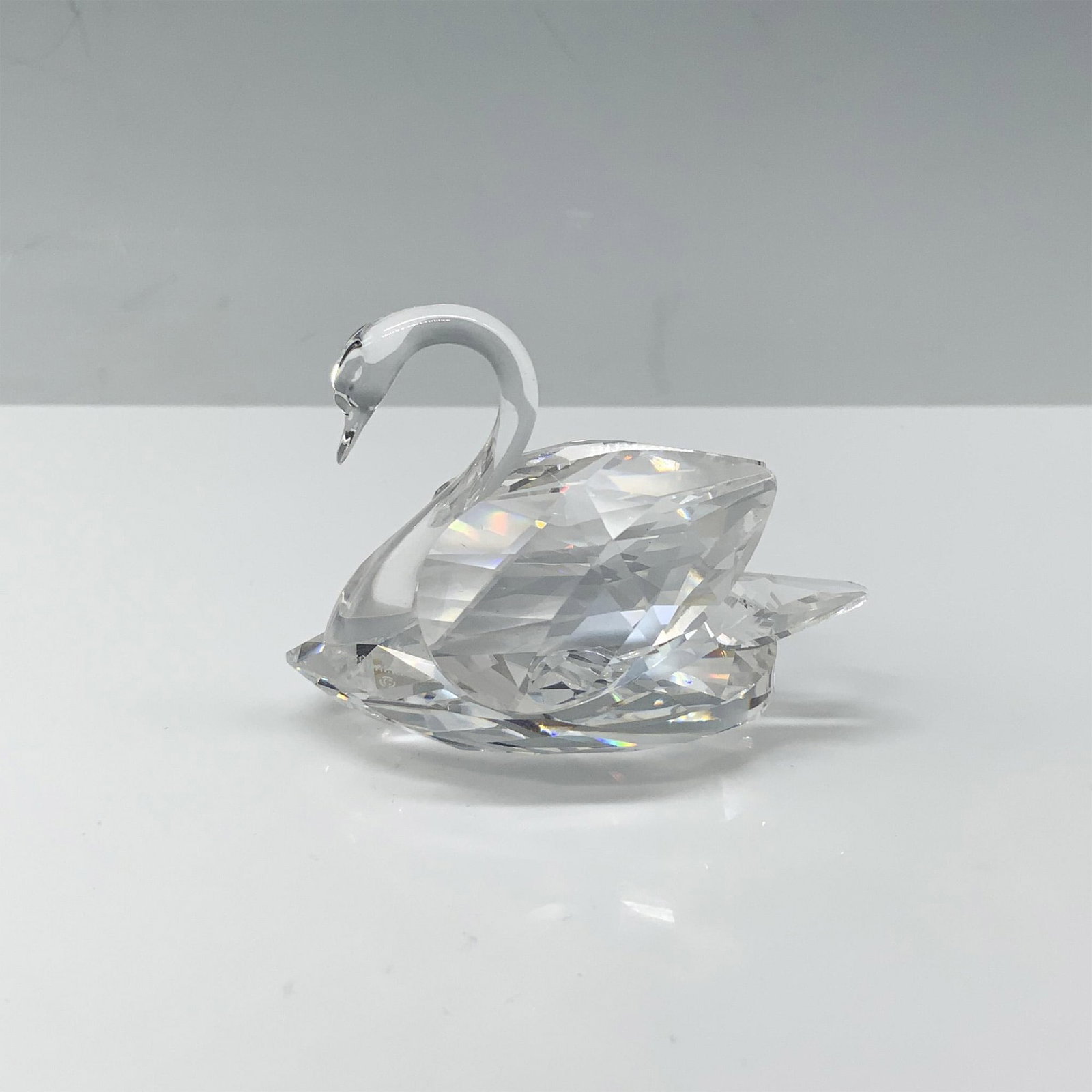 Swarovski Crystal Figurine, Swan 010005: Stunning figure of a crystal swan with its wings tucked behind them. Swarovski backstamp. This item has its original box 3.75"H x 3.25" dia. Certificate of Authenticity included. Artist: Max Schreck I