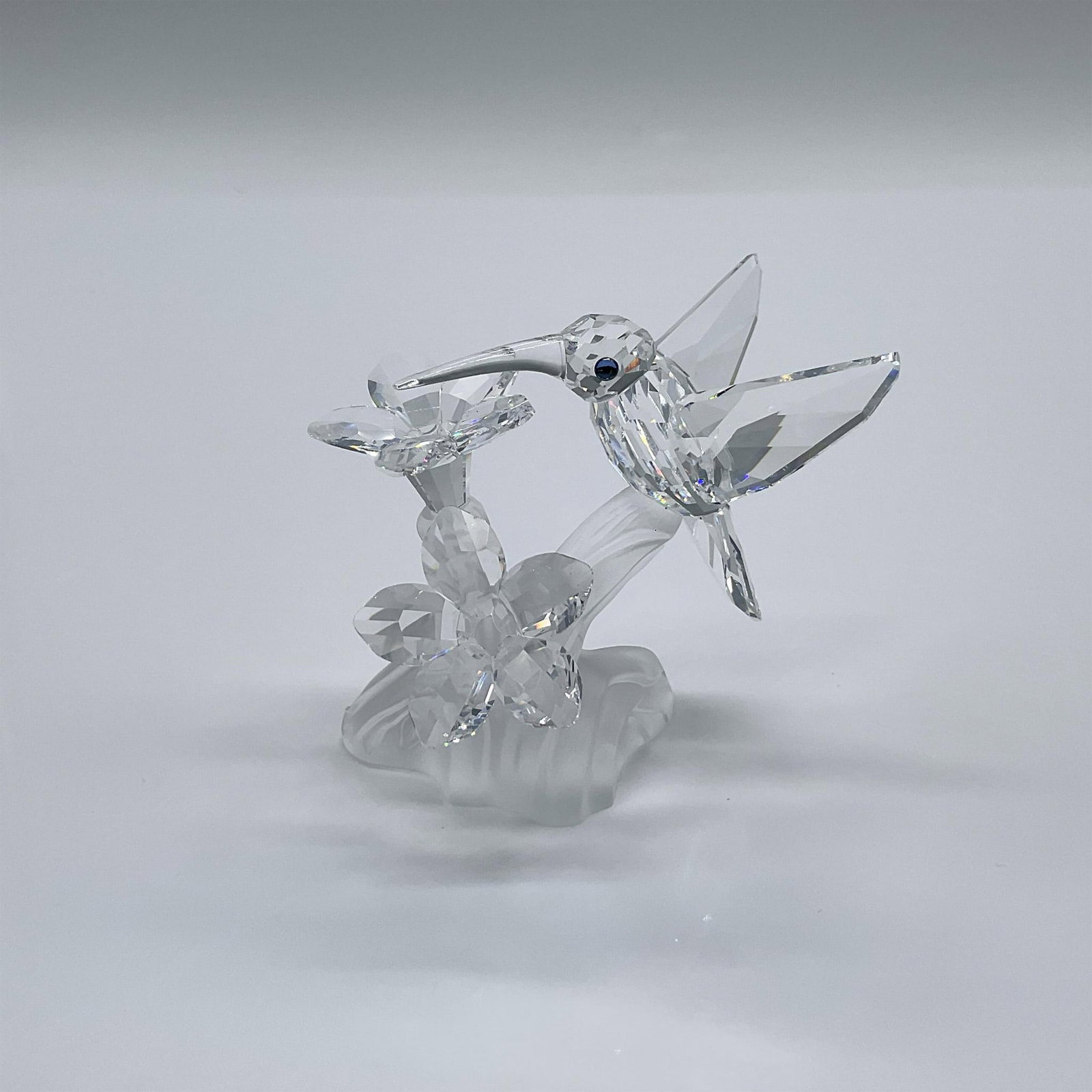 Swarovski Silver Crystal Figurine, Hummingbird: Part of the Among Flowers And Foliage collection, and later Feather Beauties theme. A clear crystal hummingbird and flowers on a frosted crystal base. Swarovski swan mark. This item has its original b