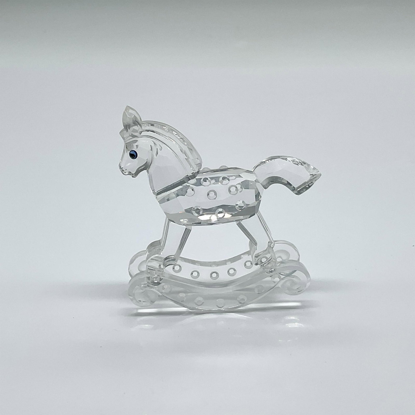 Swarovski Crystal Figurine, Rocking Horse: Part of the When We Were Young collection. Made from clear crystal and blue-black eyes. Swarovski swan mark. This item has its original box: 4.75"W x 3.75"H. Artist: Gabriele Stamey Issued: 1994 - 200
