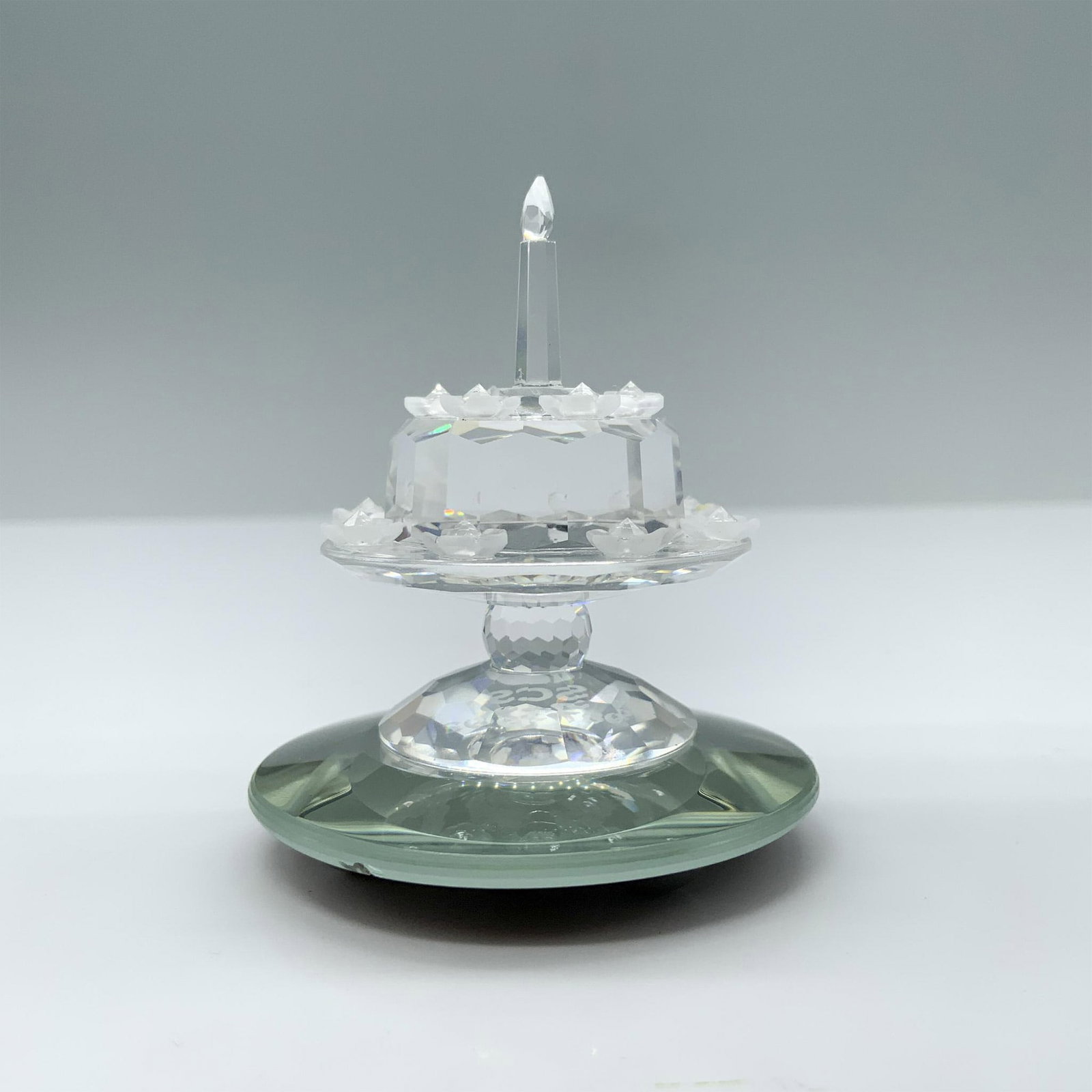 Swarovski Crystal Figurine, Birthday Cake: Limited edition SCS birthday cake made to commemorate the 5th anniversary of the SCS. Clear crystal cake on a stand decorated with frosted crystal flowers. Swarovski swan mark. This item has its origi