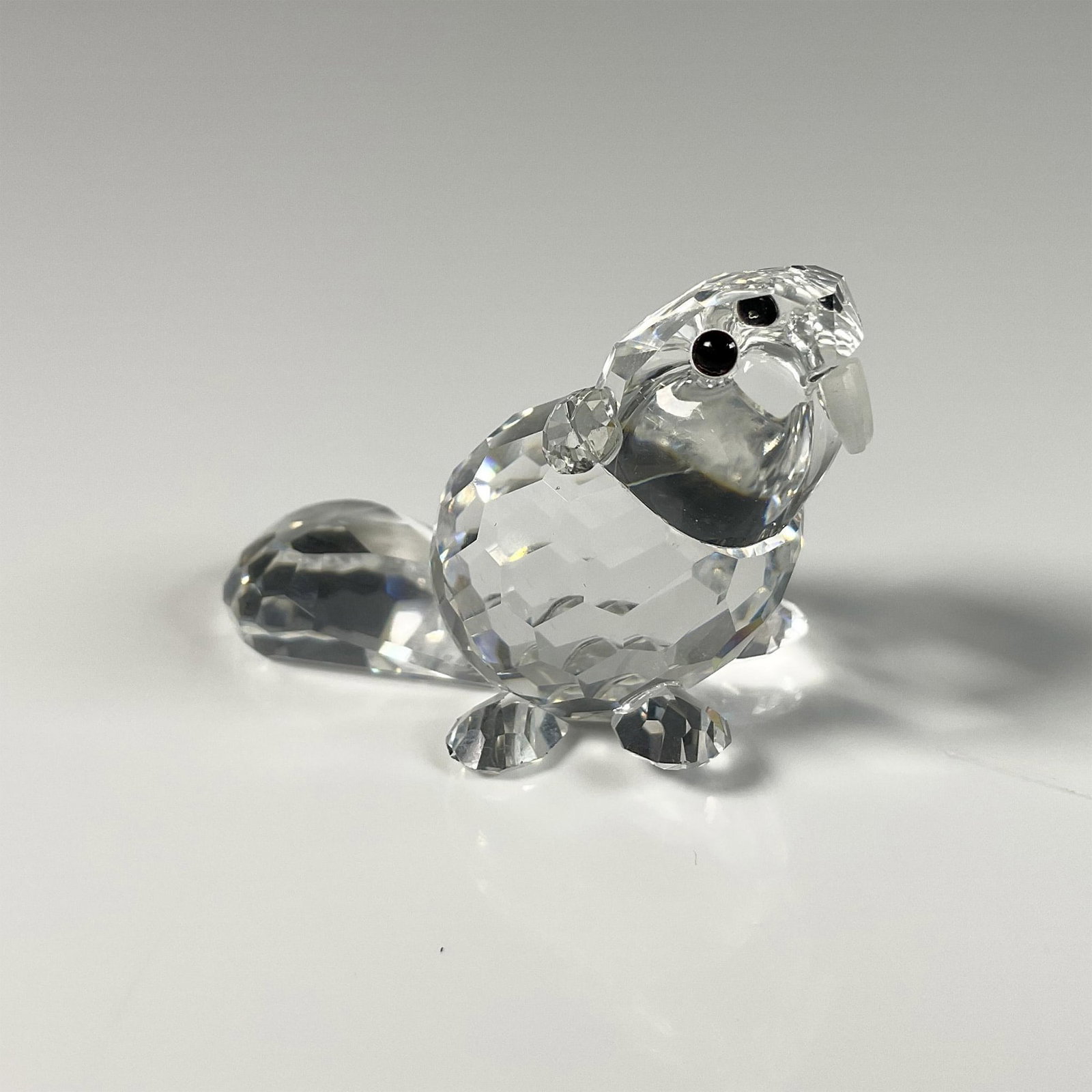 Swarovski Crystal Figurine, Beaver Baby Sitting: Adorable clear crystal beaver figure with frosted teeth from Endangered Species group. Gorgeous crystal cut in its body. Swarovski swan mark. This item includes an original box: 3.25"W x 2.5"H. 164638