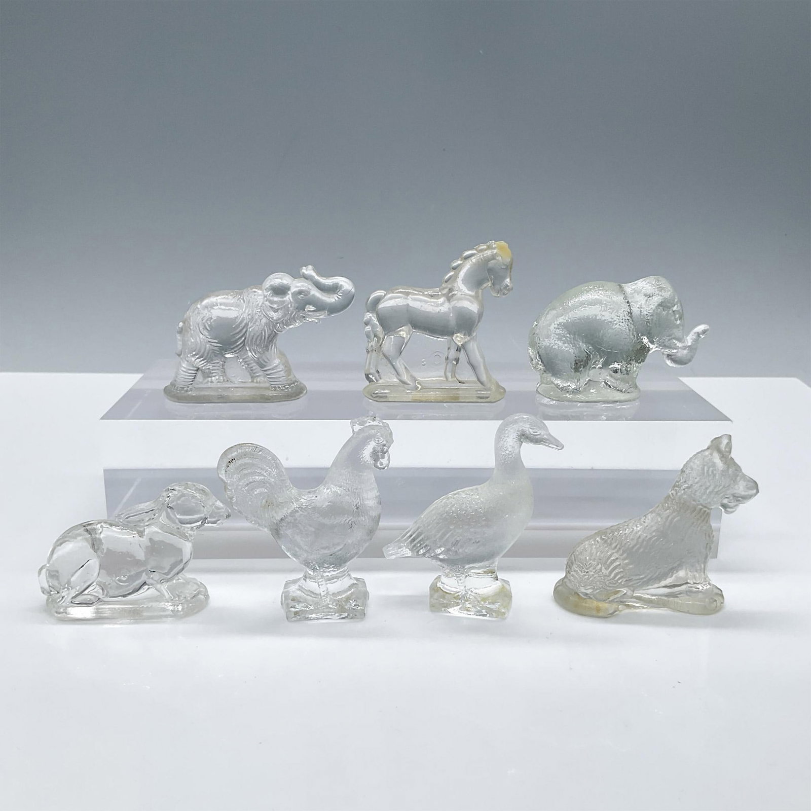 7pc Vintage Mini Glass Animal Figurines: Beautiful assortment of clear glass animals, includes: 2 Elephants, 1 Bunny, 1 Duck, 1 Chicken, 1 Dog, 1 Horse. Tallest piece measures: 2''L x 0.75''W x 2.5''H. Issued: 20th century Dimensions: See De