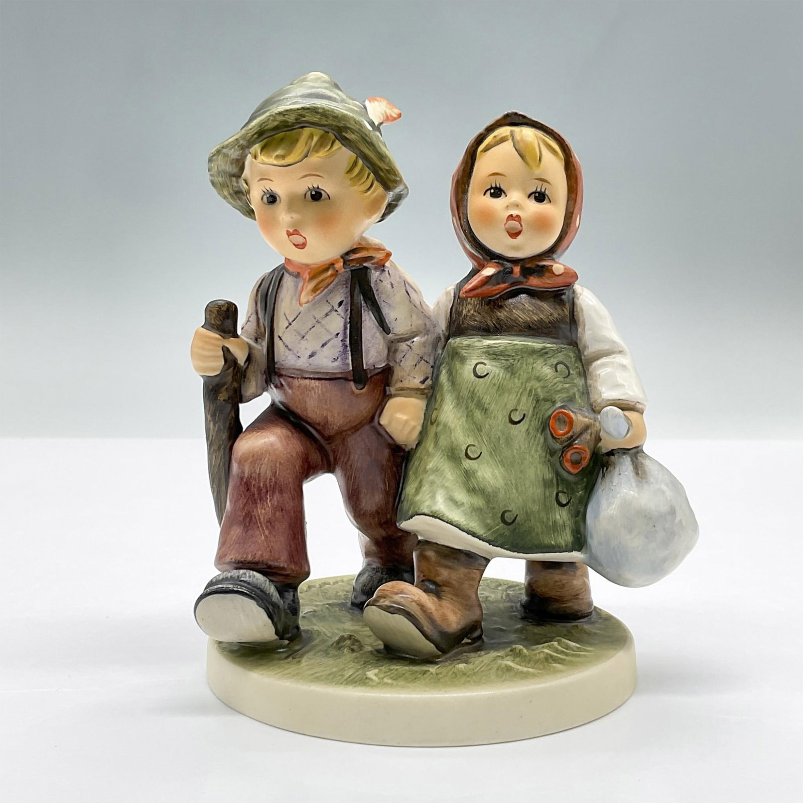 Goebel Hummel Figurine, Going Home: This porcelain figure features a boy and girl on a walk, holding hands. Marked Goebel Hummel 383. Issued: 1972 Dimensions: 4"L x 3.5"W x 5"H Manufacturer: Goebel Hummel Country of Origin: Germany