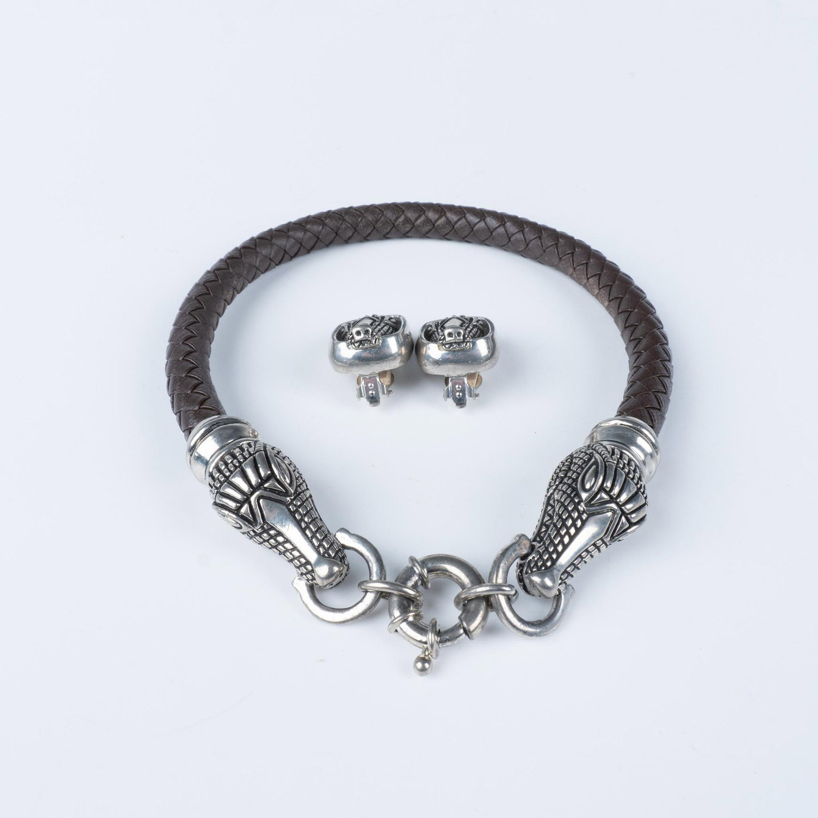 Cabot Alligator Choker Necklace & Clip On Earrings: Beautiful set in the style of Barry Kieselstein Cord. The brown braided leather choker necklace measures approximately 17"L. The clip-on earrings measure approximately 1.25"L x 1"W. Issued: 1996 Dimen