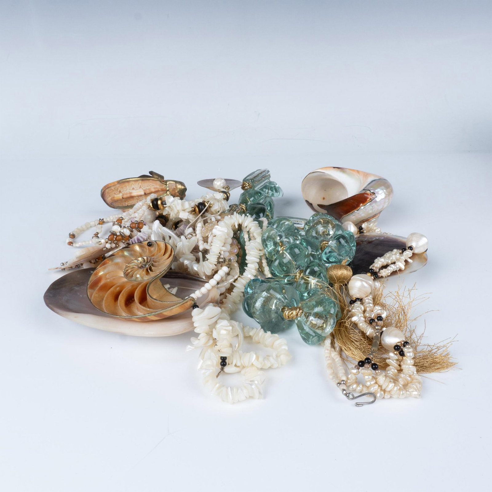 10pc Lot of Ocean Seashell Necklaces and Conch Shells: Beach theme lot with mother of pearl, sea glass, and seashell necklaces and two conch shells. The longest necklace is approximately 31"L with a 7"L tassel. Dimensions: See Description
