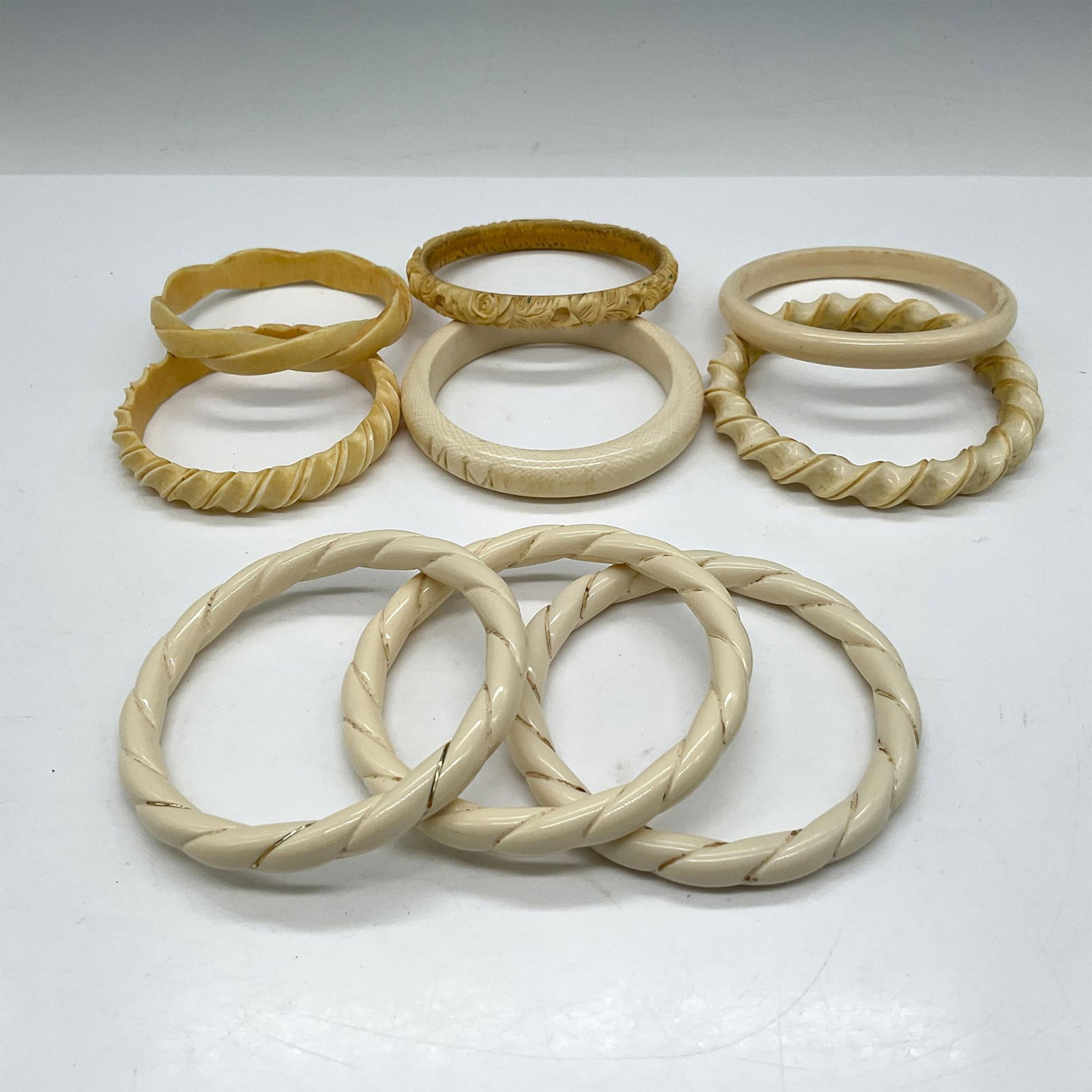 9pc Vintage Bone Bangle Bracelets: Lot includes twisted, etched and braided bracelets. Issued: 20th century Dimensions: 3.25" dia.