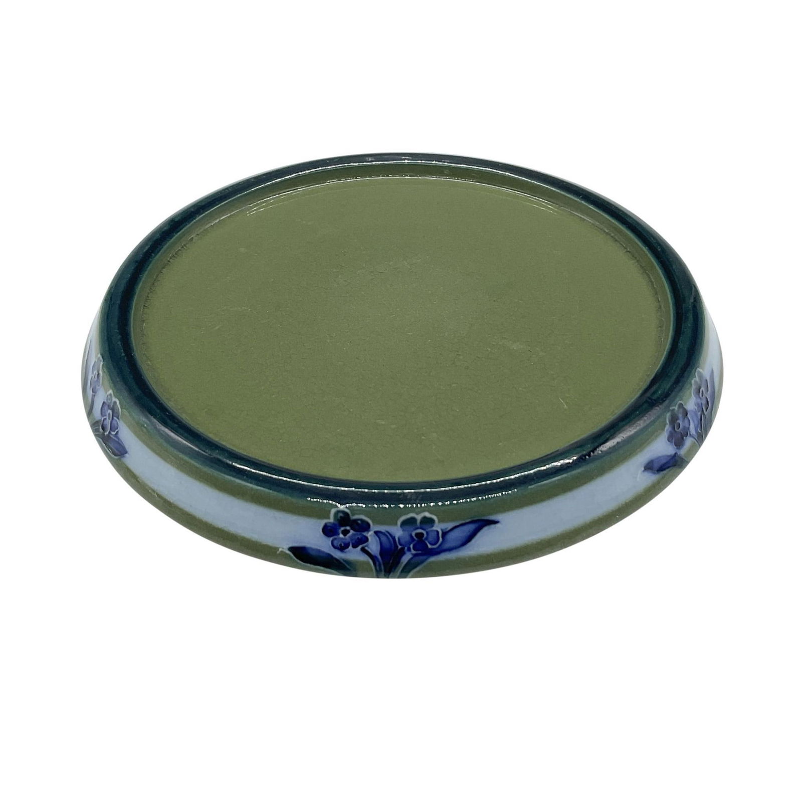 Macintyre Ceramic Blue Floral Teapot Trivet: An English pottery round stand in a blue and green glaze. decorated with whimsical blue five-petal flowers in a tubeline outline. Macintyre J M & Co. Burslem England backstamp. Issued: Early 20th cent