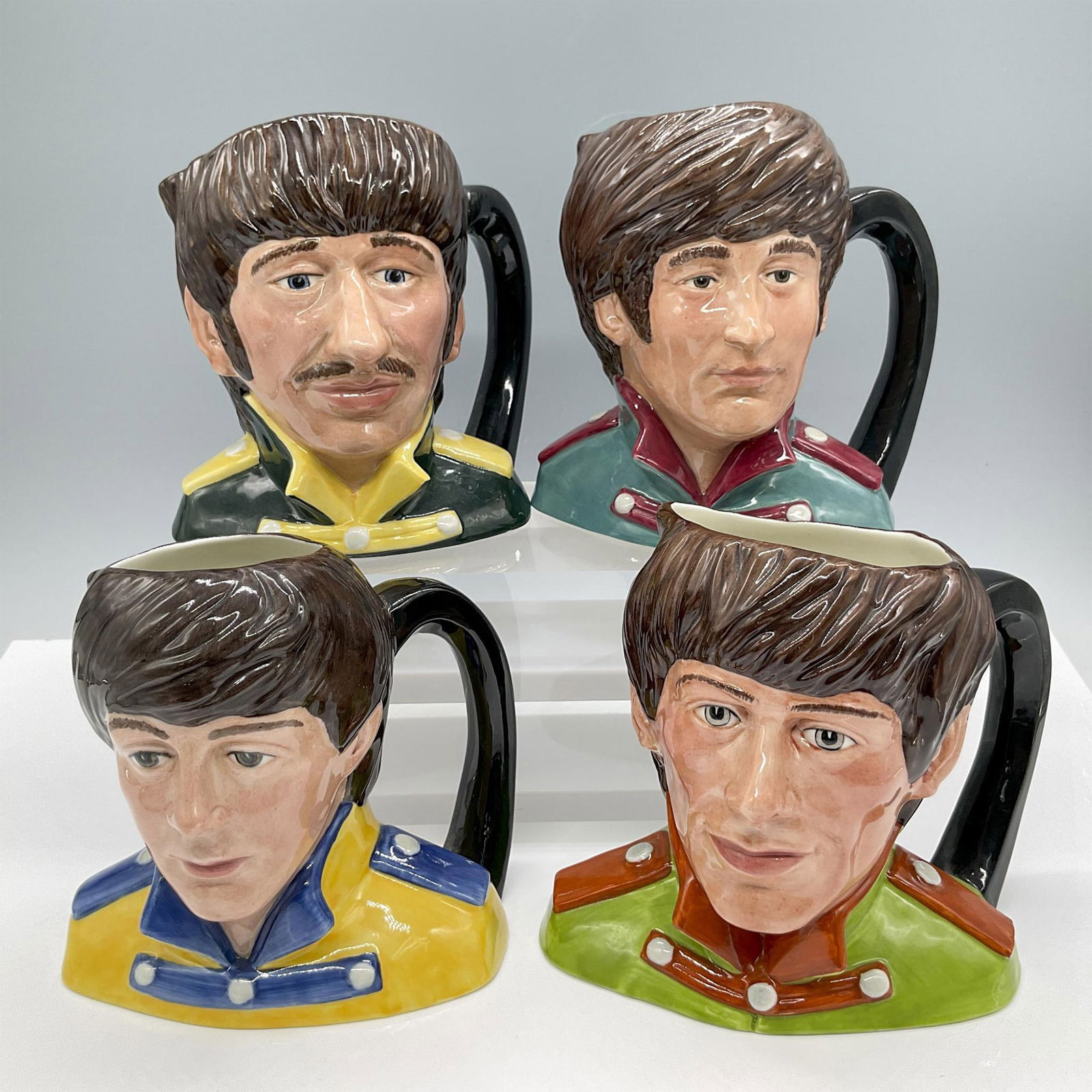 4pc Royal Doulton Odd Size Character Jugs, The Beatles: Glossy finish. Features the fourth Beatles in their jackets with epaulettes. Includes: Ringo Starr D6726; Paul McCartney D6724; John Lennon D6725; George Harrison D6727. Royal Doulton backstamp. Large
