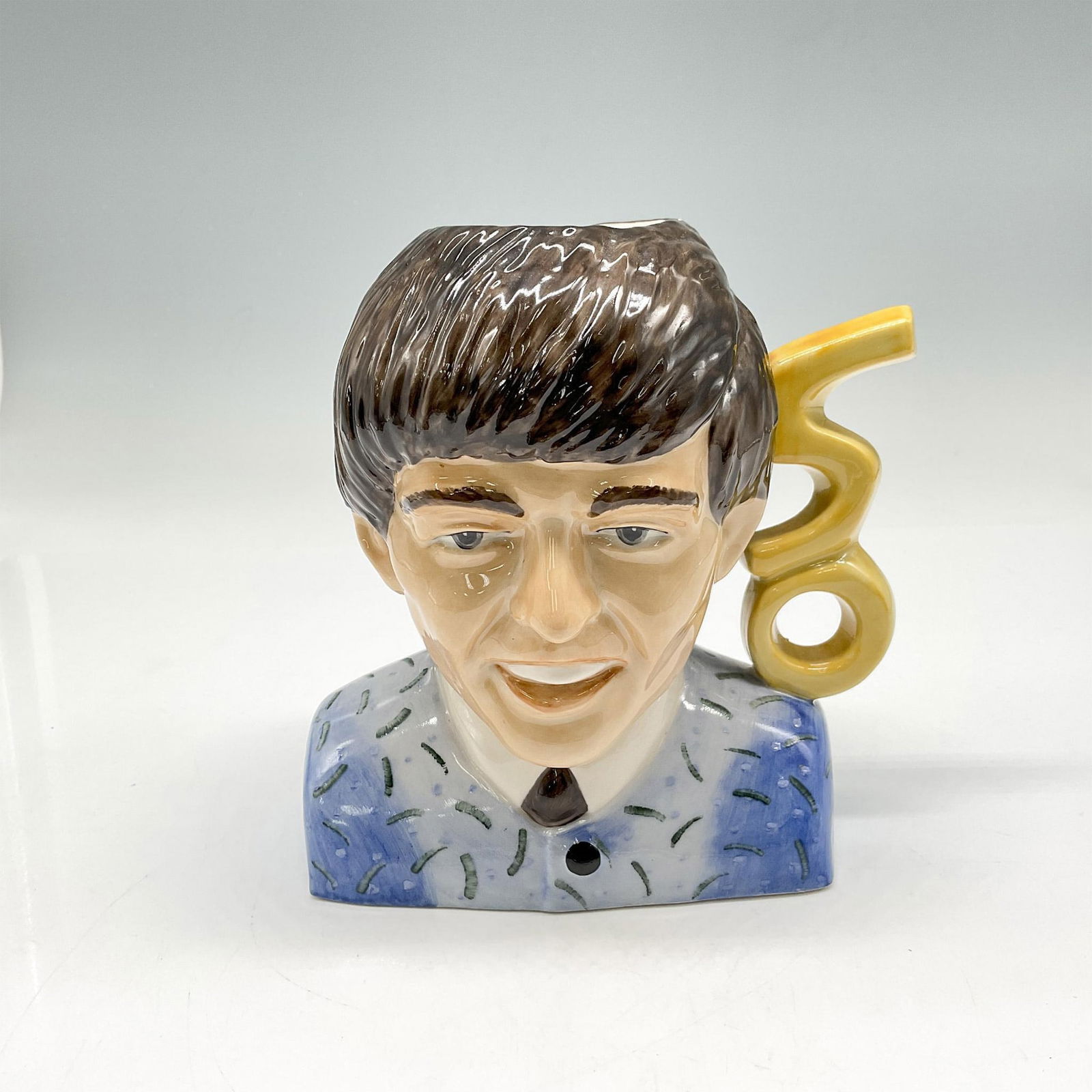 Peggy Davies Rare Artists Original Proof Beatles Character Jug, George Harrison: Glossy George Harrison jug, colored in brown, blue and yellow. Handle designed as 50 for anniversary. Peggy Davies and Victoria Bourne. Artist: Victoria Bourne Issued: 20th century Dimensions: 5.25"L