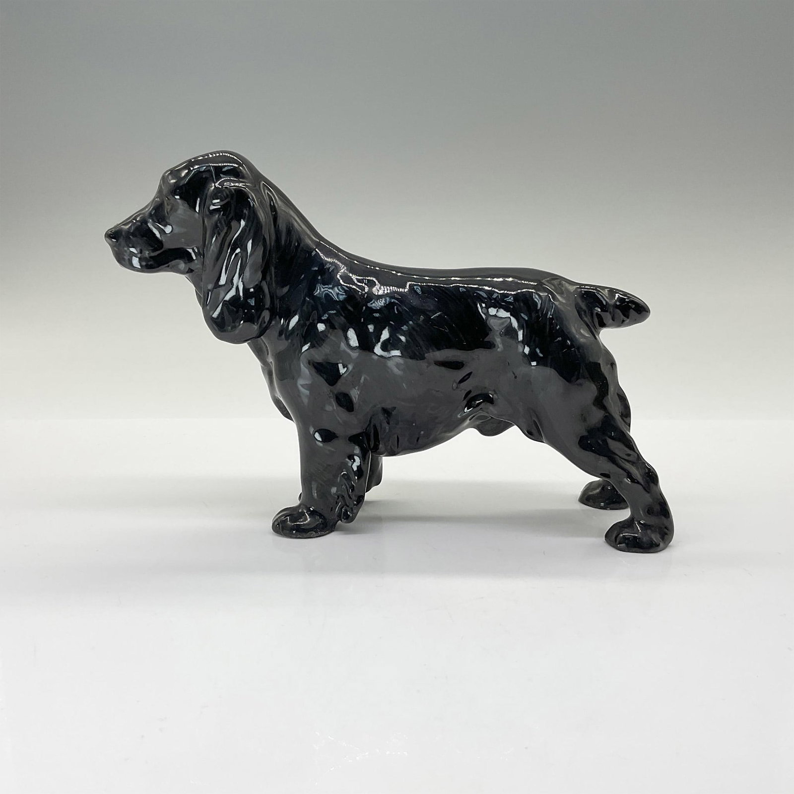 Royal Doulton Dog Figurine, Cocker Spaniel HN1020: Part of the Sporting Dog Series, this fine bone china figurine is modeled in black with fine, hand painted hairs on the coat, muzzle, and expressive eyes. Royal Doulton backstamp. Artist: Frederick Da