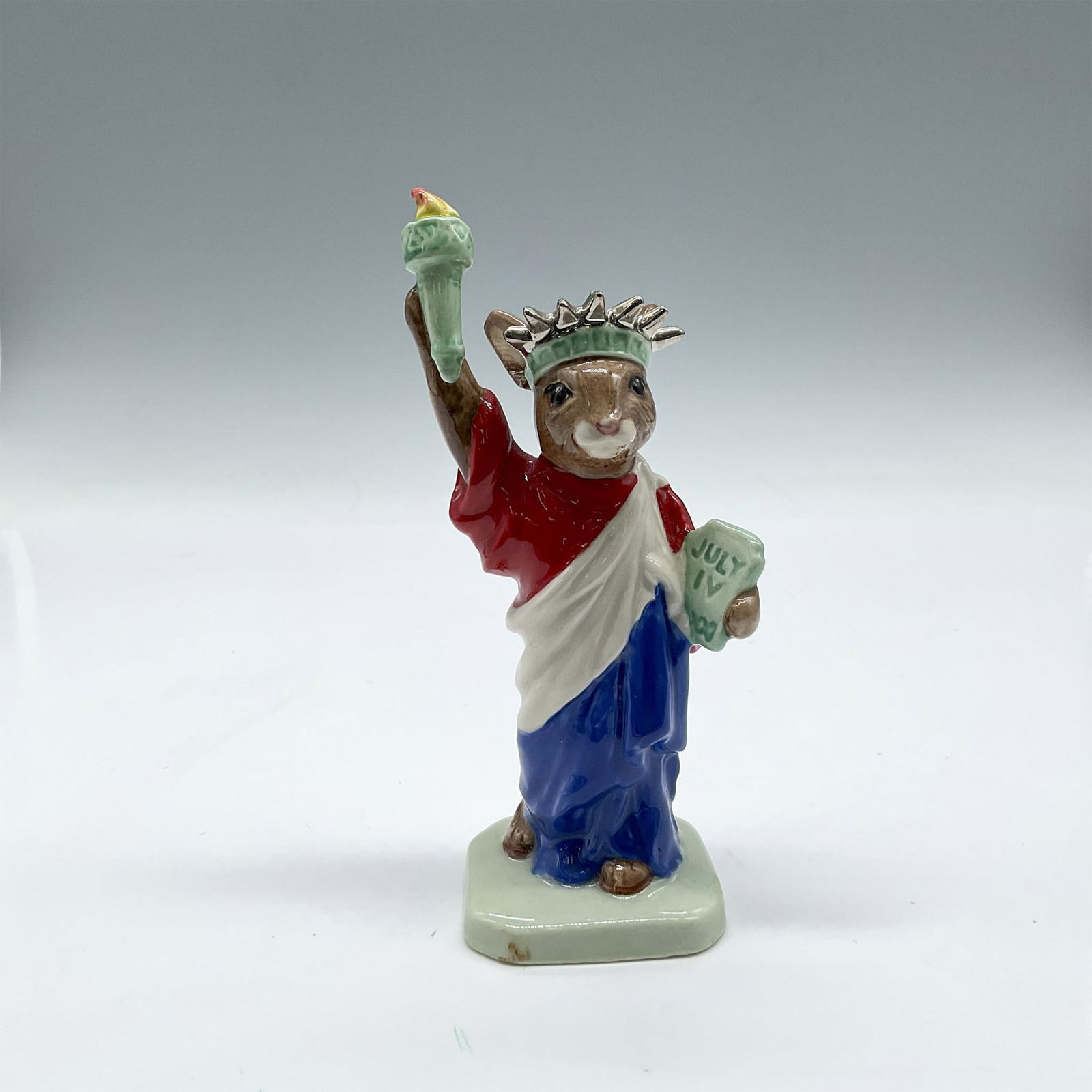 Statue of Liberty DB198 - Royal Doulton Bunnykins: Special edition American Heritage series figure, colored in red, white and blue. Royal Doulton Bunnykins backstamp. Artist: Caroline Dadd, Amanda Hughes-Lubeck Issued: 1999 Dimensions: 1.75"L x 1.75"W