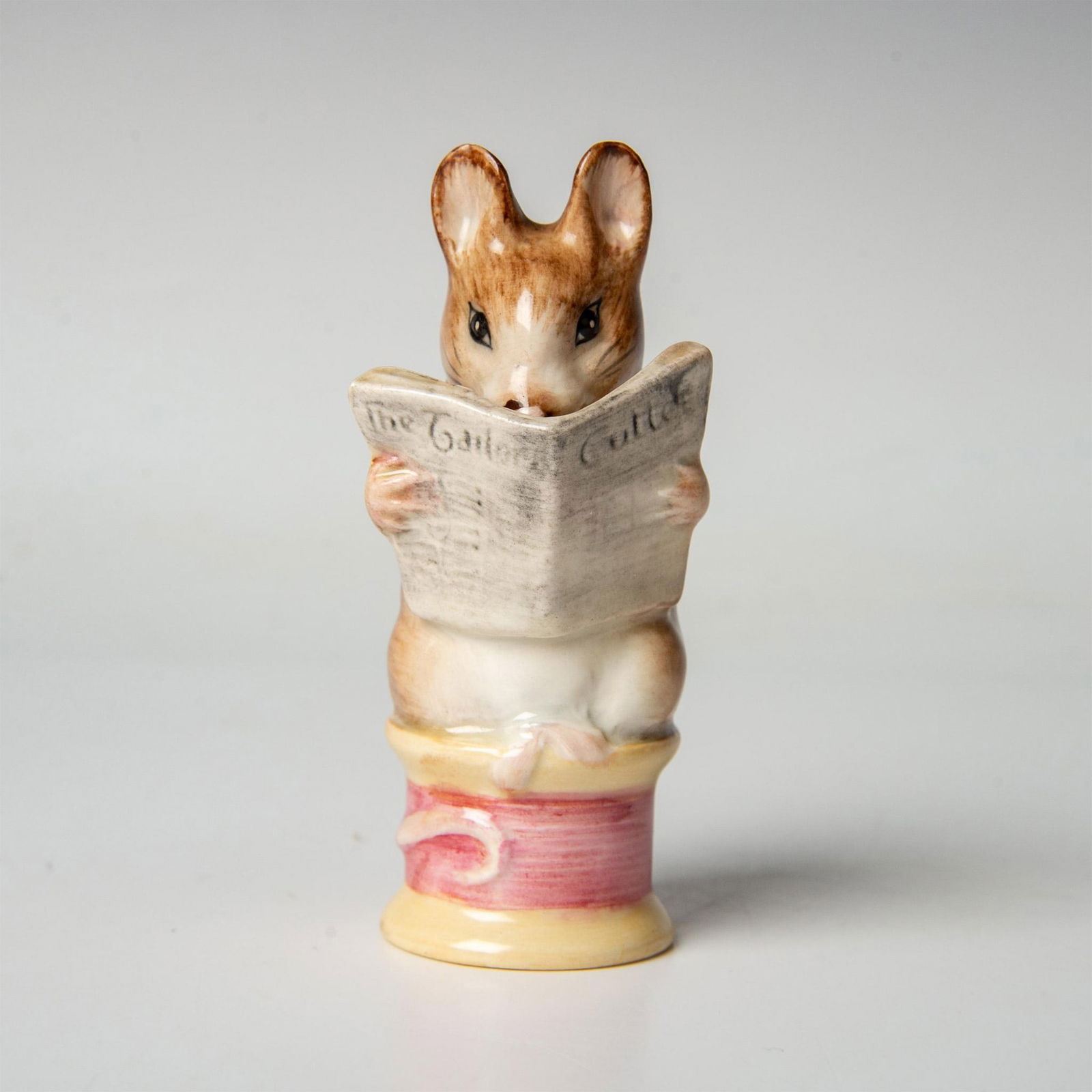 Beswick Beatrix Potter Figurine, Tailor of Gloucester, Gold: An adorable mouse sitting on a magenta thread. Includes the original box, dimensions: 2''L x 2.5''W x 5.5''H. Beswick Gold Oval backstamp. Issued: 20th century Dimensions: 1.25''L x 1.5''W x 3.75''H M