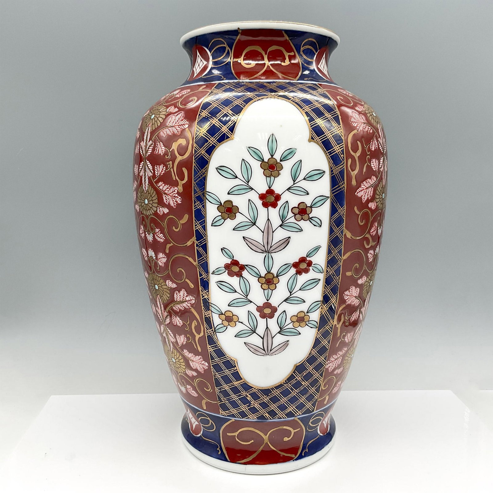 Japanese Porcelain Imari Ware Vase: White porcelain decorated in blue underglaze with gilt overglaze and other polychrome colors. Lattice and floral designs enhance the piece. Yamayo foil sticker. Japanese characters identifying Imari W