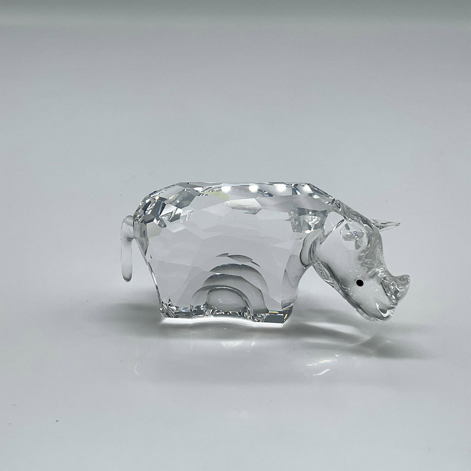Swarovski Crystal Figurine, Rhinoceros: Small clear crystal figure with black crystal inset eyes. Swarovski backstamp. 622941. This item has its original box: 4"H x 3.25" dia. Artist: Anton Hirzinger Issued: 2003 - 2006 Dimensions: 2.25"L x