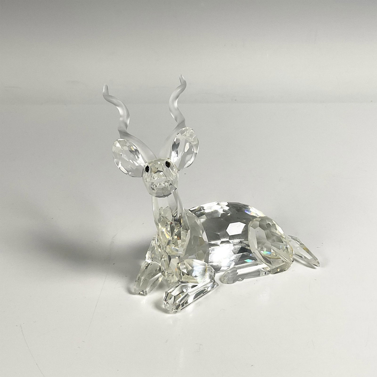 Swarovski Crystal Figurine, Kudu: 1994 SCS edition figure of Kudu with frosted crystal twisted horns, as the second of the Inspiration Africa trilogy. Swarovski swan mark. This item includes its original box: 7.5"L x 7.5"W x 6.25"H. 1