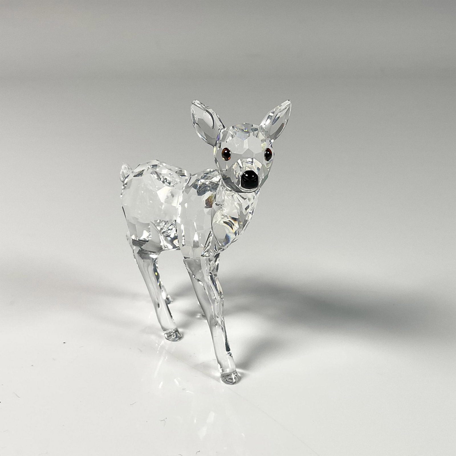 Swarovski Crystal Figurine, Fawn: Elegant clear crystal fawn figure from Rare Encounters collection. Beautiful clear facetted body and smooth molded legs. Swarovski swan mark on the leg. This item includes an original box: 5"W x 3.75"