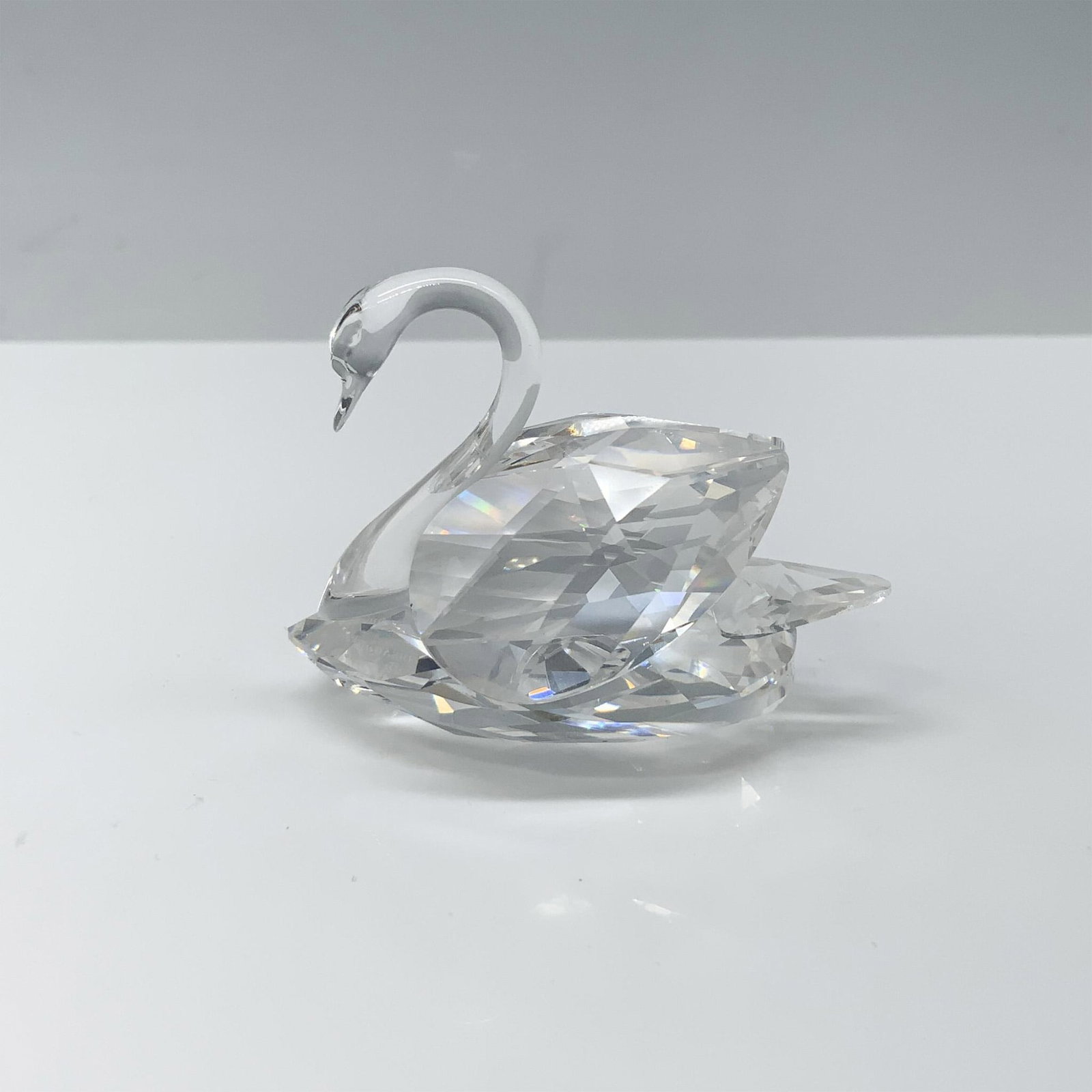 Swarovski Crystal Figurine, Swan 010005: Magnificent figure of a crystal swan with its wings tucked behind them. Swarovski backstamp. This item has its original box 3.75"H x 3.25" dia. Certificate of Authenticity included. Artist: Max Schrec