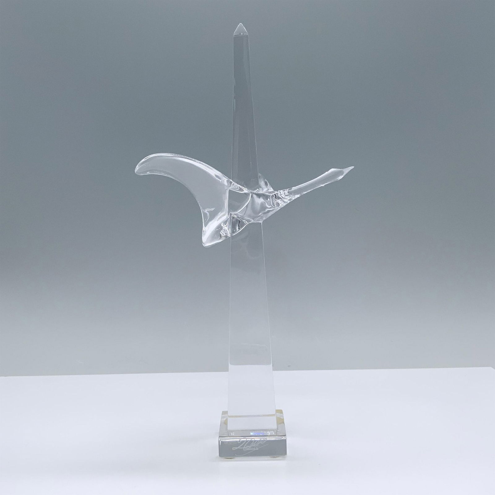 Baccarat Crystal Figurine, Millennium Passage: Limited edition figure features an obelisk with a bird in flight wrapped around it. Combining sleek lines with a dynamic design. Baccarat France backstamp, 2000 is etched on the base. Dimensions: 6"L