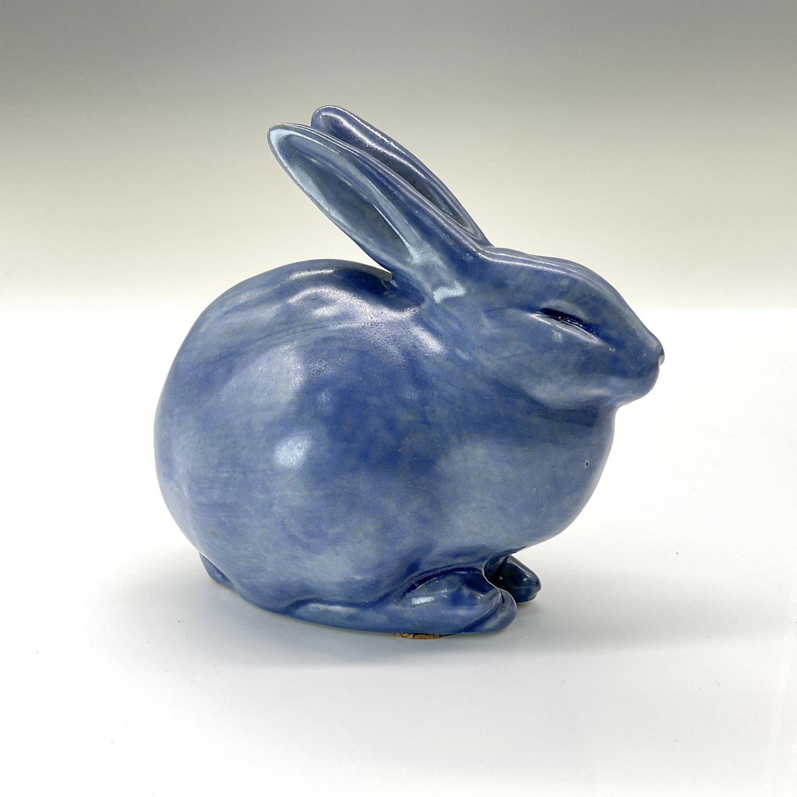 Rookwood Present Day Pottery Animal Figurine, Blue Rabbit: Adorable crouched rabbit crafted from the original master mold #6160 from 1928. Finished in a lovely blue glossy glaze. Rookwood backstamp. This item has its original box that measures 5.5"L x 4"W x 3
