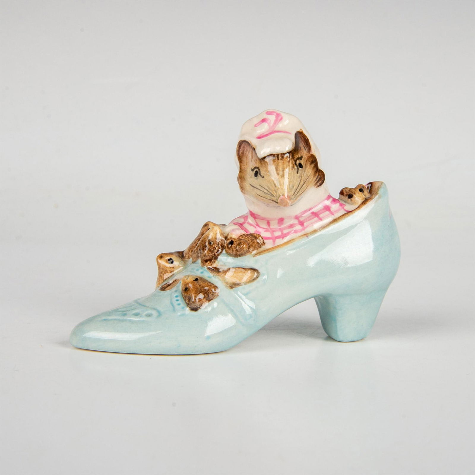 Beswick Beatrix Potter Figurine, Old Woman Who Lived In Shoe: Mother mouse and her children residing in a high-heel, light blue shoe. This item has its original box measuring 3"L x 3"W x 4.25"H. Beswick backstamp. Artist: Colin Melbourne Issued: 1959-1998 Dimens