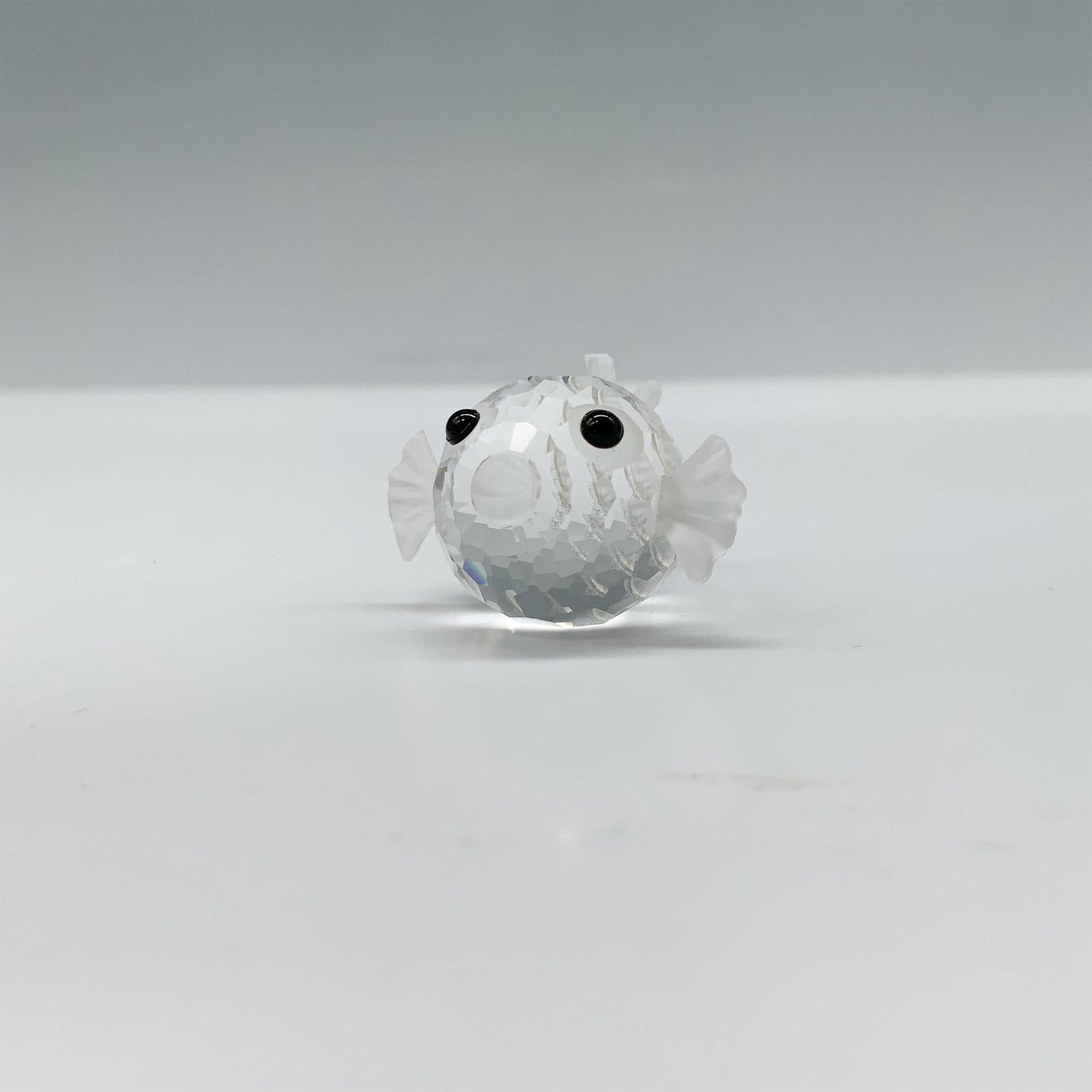Swarovski Crystal Figurine, Mini Blowfish: Adorable clear faceted crystal blowfish with frosted fins that is the smallest of the three blowfish produced by Swarovski. Part of the South Sea theme. Swarovski backstamp. Artist: Team Issued: 1987-