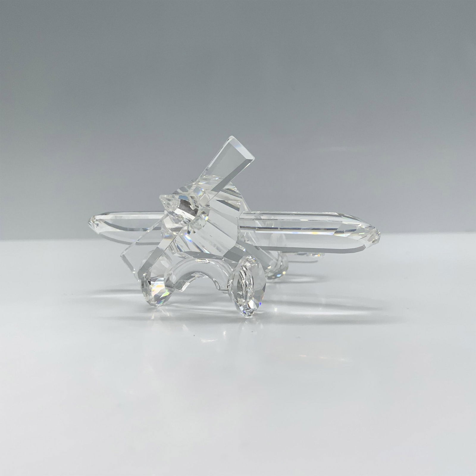 Swarovski Crystal Figurine, Airplane: Charming clear crystal figure of a propeller biplane that was part of the When We Were Young collection. Swarovski backstamp. Artist: Adi Stocker Issued: 1990-1999 Dimensions: 3"L x 3"W x 1.25"H Manuf