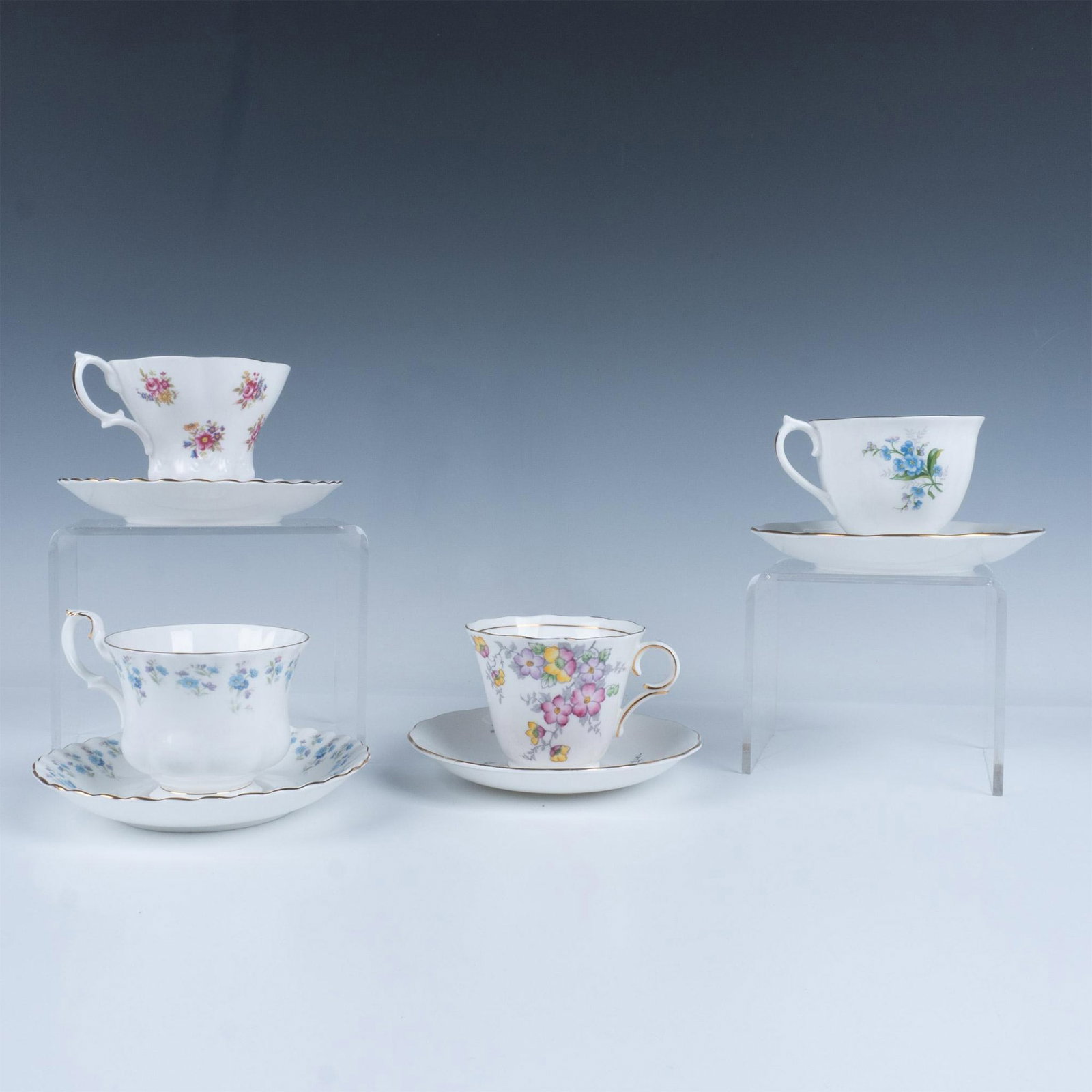 8pc Bone China Tea Cups+Saucers, Royal Albert and Colclough: Mixed lot of 3 cups and saucers from Royal Albert and one cup and saucer from Colclough China. All have floral patterns with gilt detailing. Largest cup measures 4.5"L x 3.75"W x 3"H. Largest saucer m