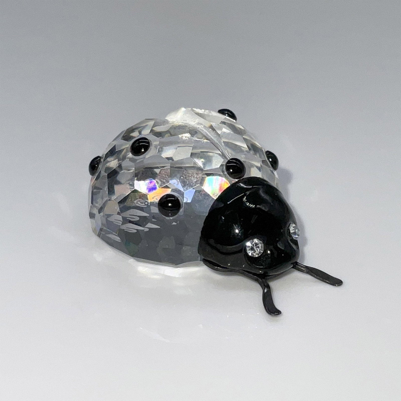Swarovski Crystal Figurine, Ladybird: This adorable ladybug was part of the In the Secret Garden theme group. It features a faceted crystal body with contrasting black spots and crystal eyes along with metal antennas. This item has its or