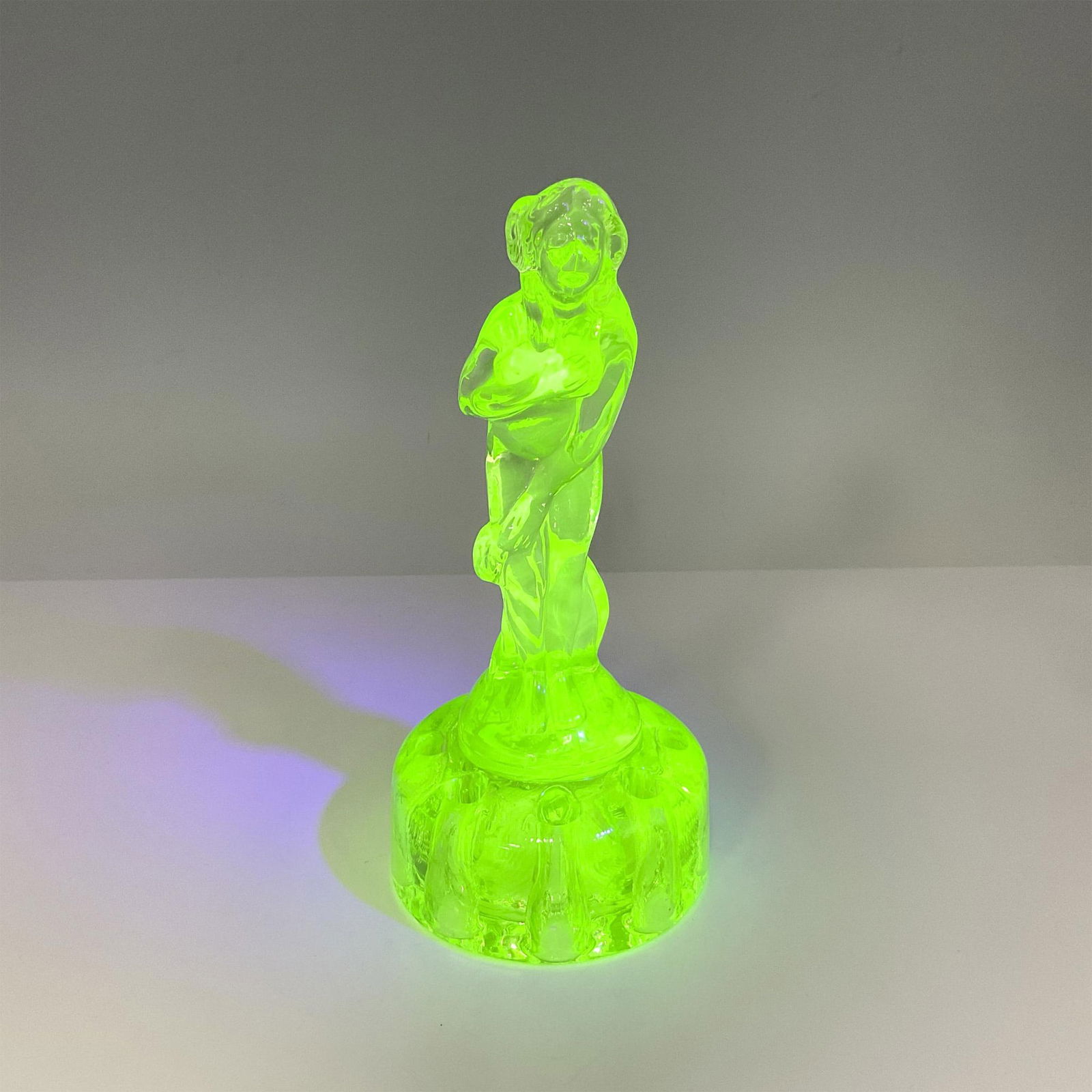 Green Uranium Glass Flower Frog, Bashful Charlotte: Smooth glass nude bending at the waist holding her hands in front of her atop flower frog. Unmarked. Issued: 20th century Dimensions: 6.75"H x 3" dia.