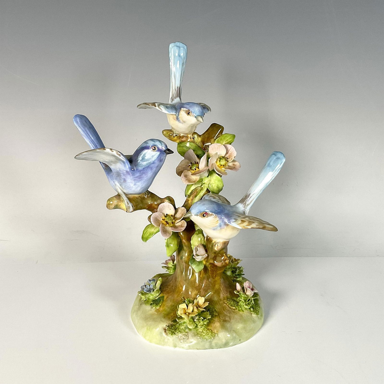 Crown Staffordshire Bone China Figurine, Blue Birds: Hand painted and hand decorated figure of three blue birds in a flowering tree, capturing a peaceful and joyful moment. Crown Staffordshire backstamp. Artist: J. T. Jones Issued: 20th century Dimensio