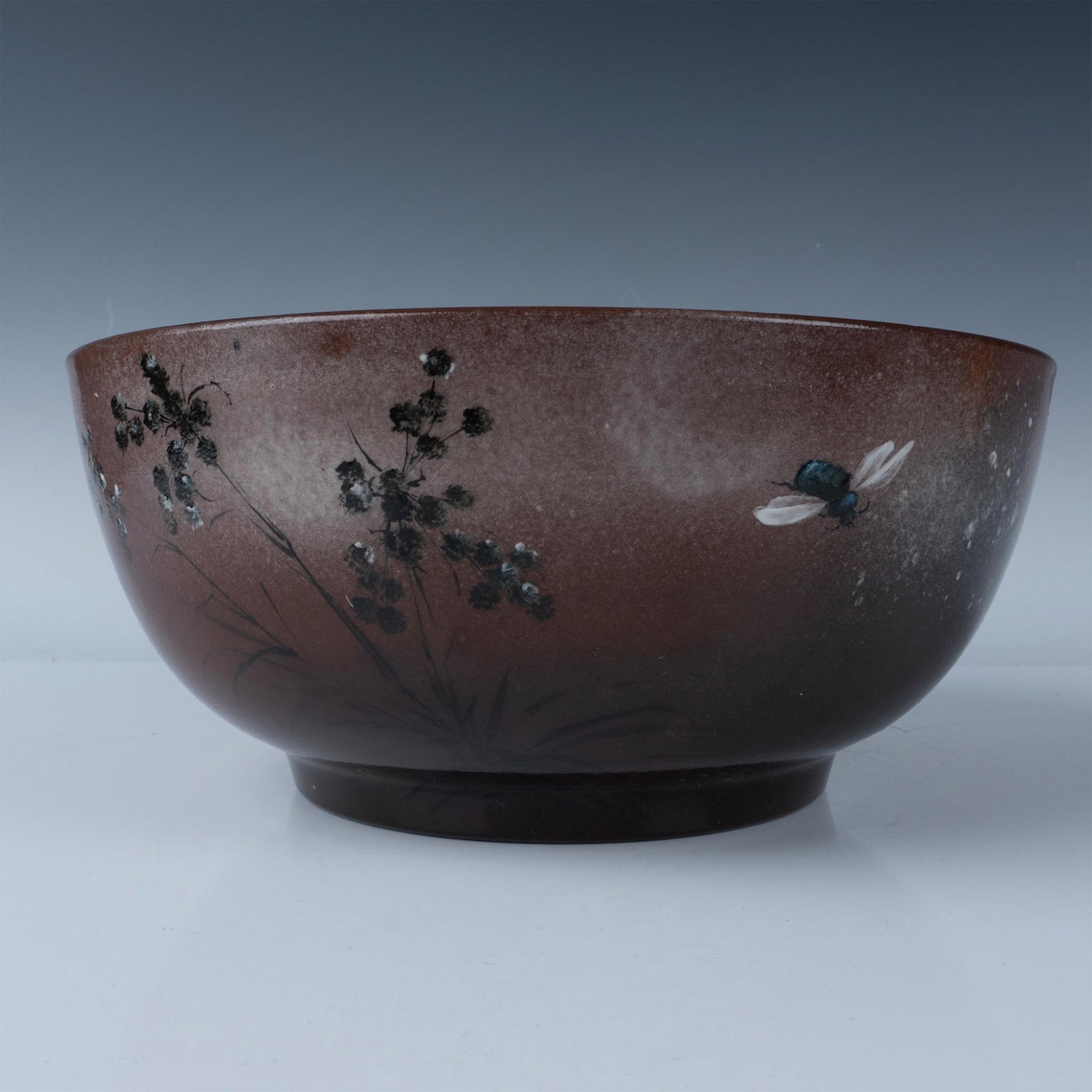 Rookwood Pottery by Fry Flower and Fly Bowl 70: Designed by Laura Fry. Antique cinnamon-brown glazed bowl, decorated with hand painted black and white flowers. A single winged-insect flies nearby. Rookwood impressed stamp. Marked 1884 R 70. Artist 