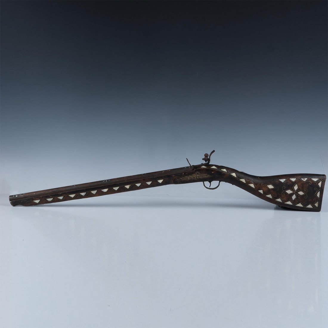 Vintage Child's Cap Gun Rifle: With incredible brass wire and mother of pearl inlay detail, the rifle is a dark stained wood with metal pipe gun barrel. The realistic lever action provides for true sense of rifle action activity. I