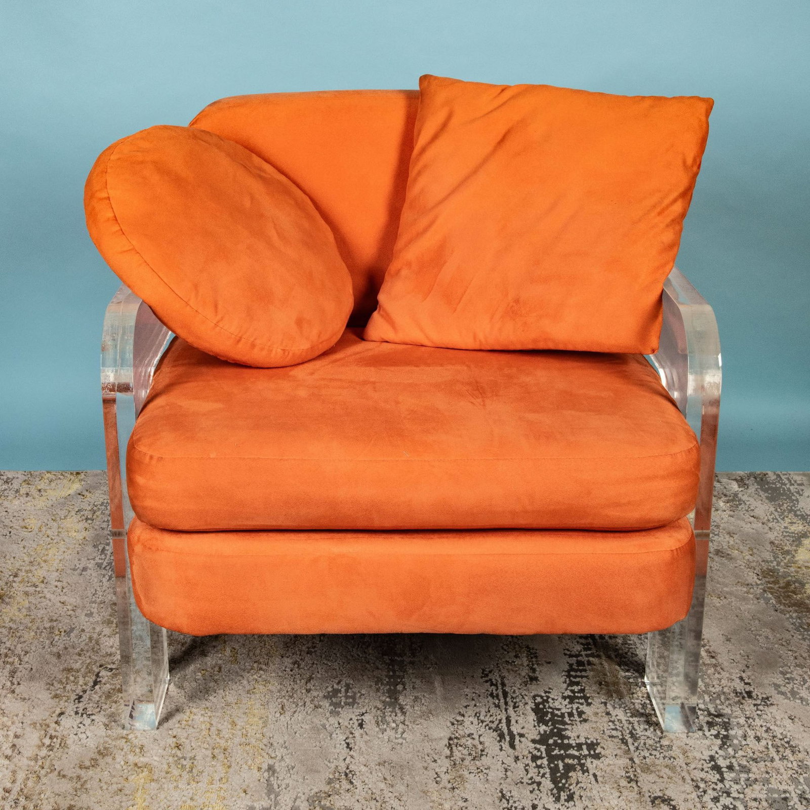 Mid Century Modern Peach and Lucite Lounge Chair: This striking mid-century modern lounge chair captures the innovative spirit of the 20th-century design movement. Upholstered in soft faux suede, the chair boasts a vibrant peach hue, providing a warm