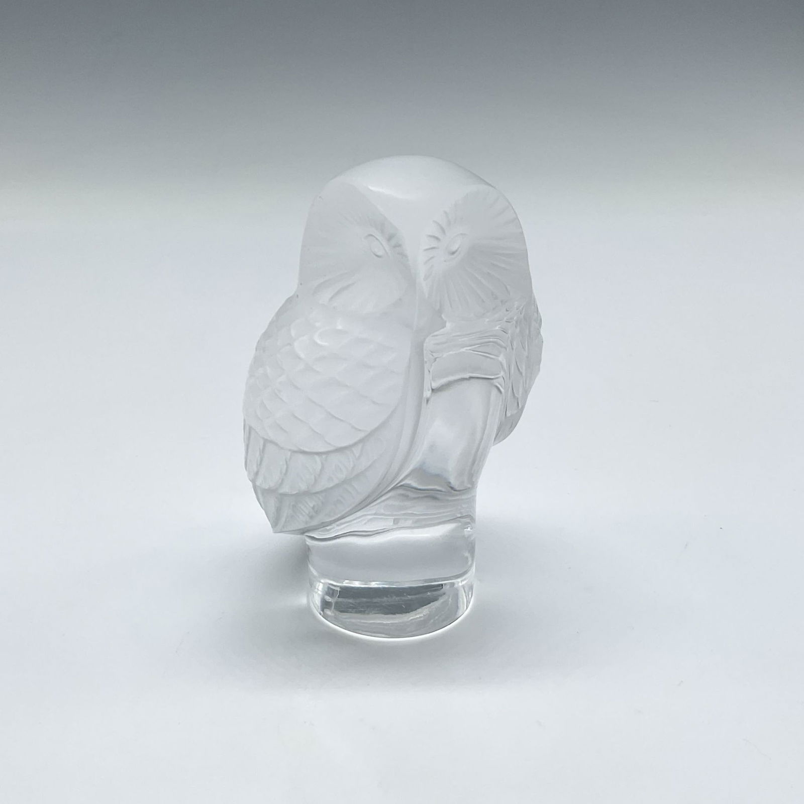 Lalique Crystal Chouette Paperweight: Frosted crystal owl sculpture on round clear base. Lalique France etched mark. Issued: 20th century Dimensions: 2.25"L x 2"W x 3.5"H Manufacturer: Lalique Country of Origin: France