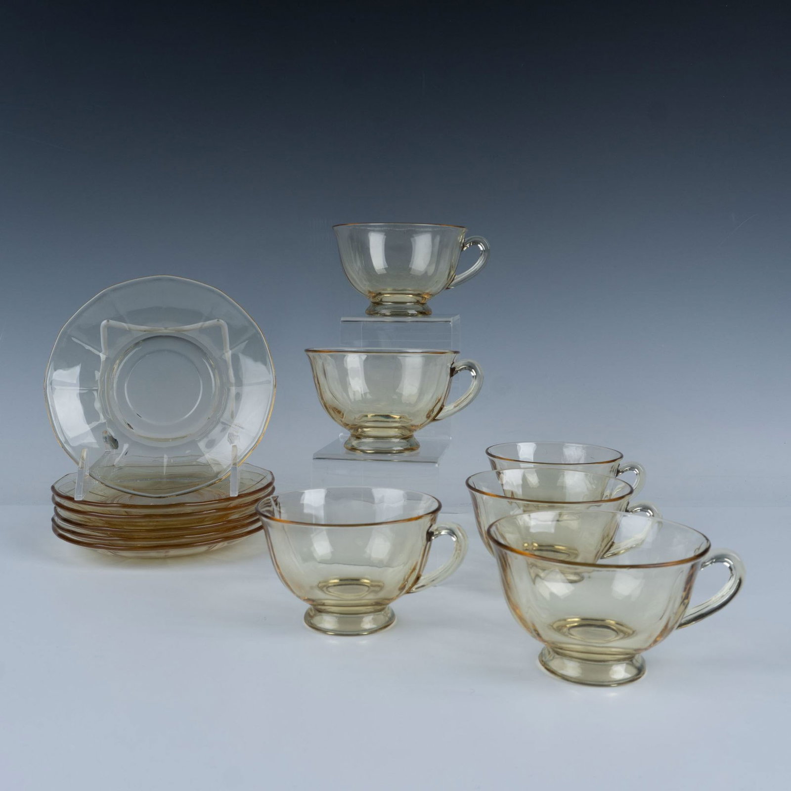 12pc Fostoria Glass Fairfax Topaz: A lovely set of six translucent topaz-colored glass cups and matching saucers, featuring a simple yet elegant panel decoration. Cup measures 2.5"H. Saucer measures 6" dia. Issued: 20th century Dimensi