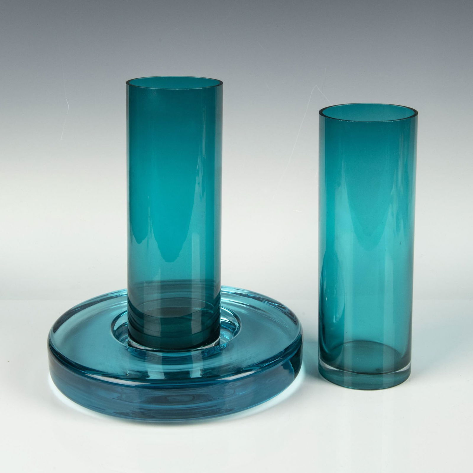 3pc Holmegaard Glass Bowl & Art Glass Vases: Stunning collection of aqua glassware that includes a round, wide rimmed bowl backstamped Holmegaard, and two cylindrical art glass vases. Largest item measures 1.75"H x 9.5" dia. Issued: 20th century
