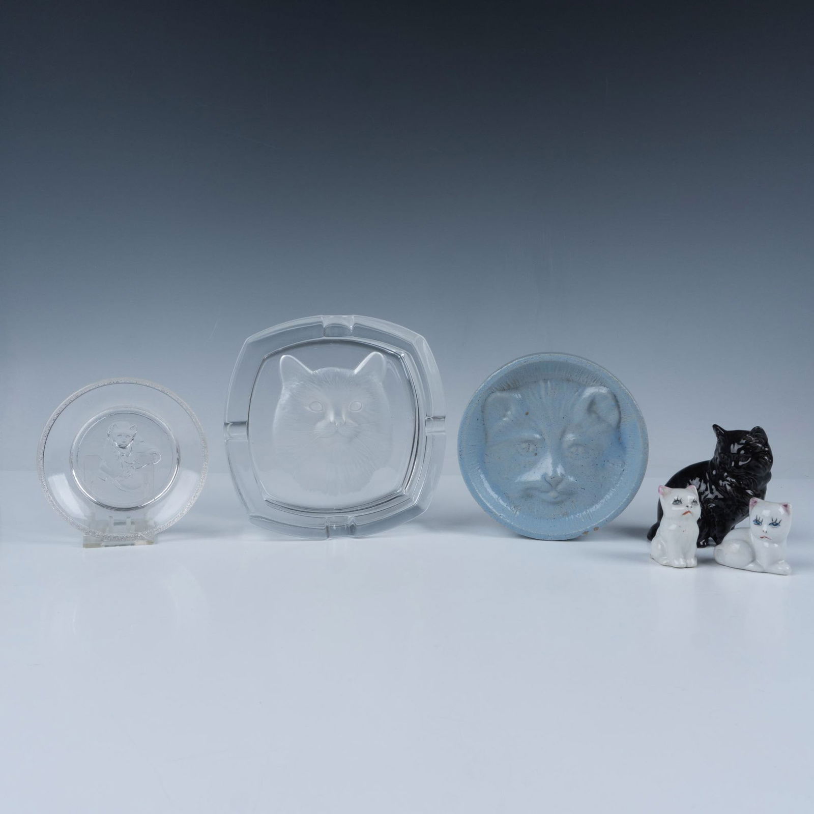 6pc Cristal d'Arques Cat Ashtray & Ceramic Cats: Six cat interest decorative objects. Includes one Cristal d'Arques crystal ashtray with a reversed etched cat; one blue glazed stoneware cat soap dish; one black ceramic cat (RCV 77 carved on bottom);