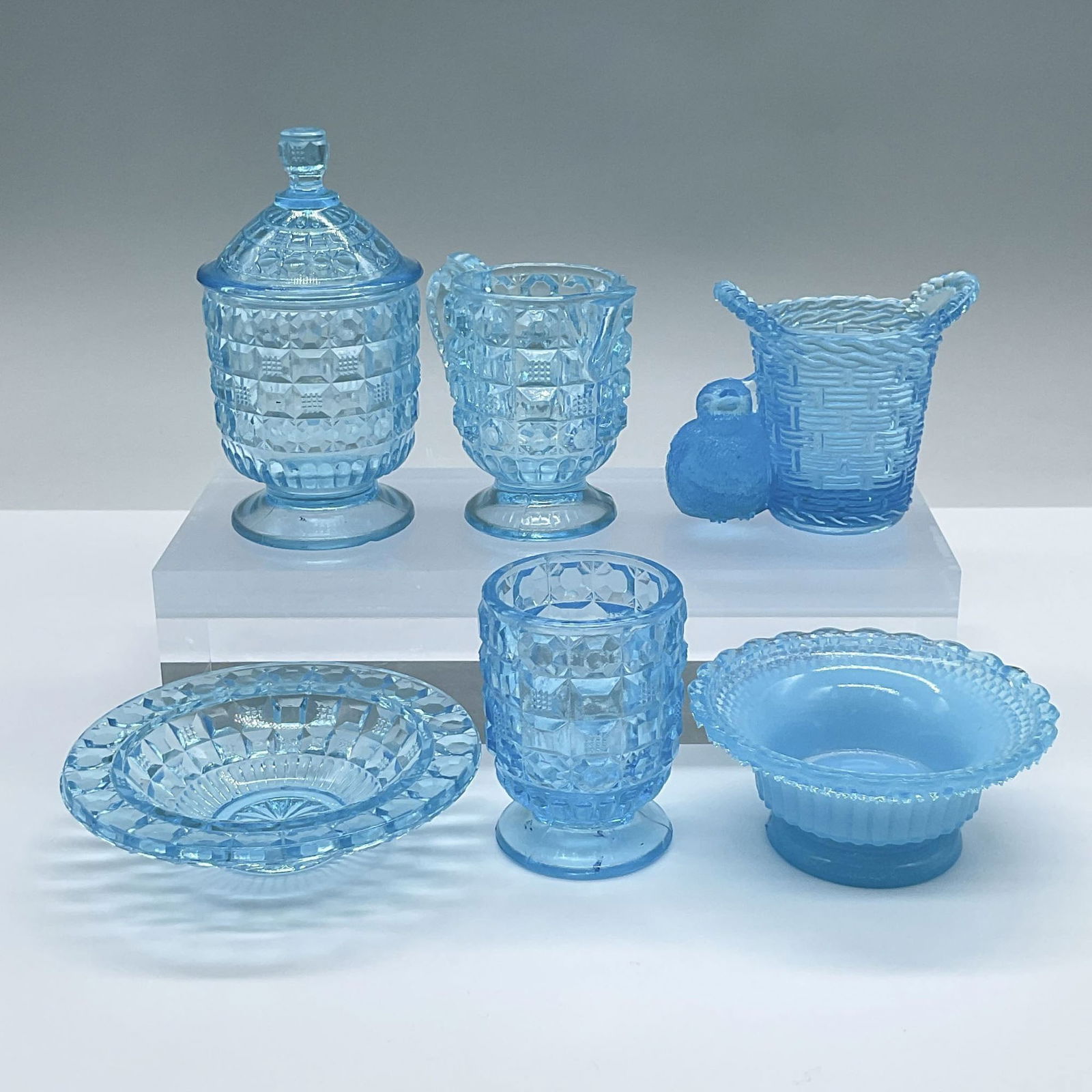 6pc Vintage Blue Glass Tableware: Features a creamer, lidded sugar bowl, spooner, and a small dish, all with a waffle pressed design. Also includes an opalescent cellar with a star dewdrop pattern at the underside, and tooth pick hold