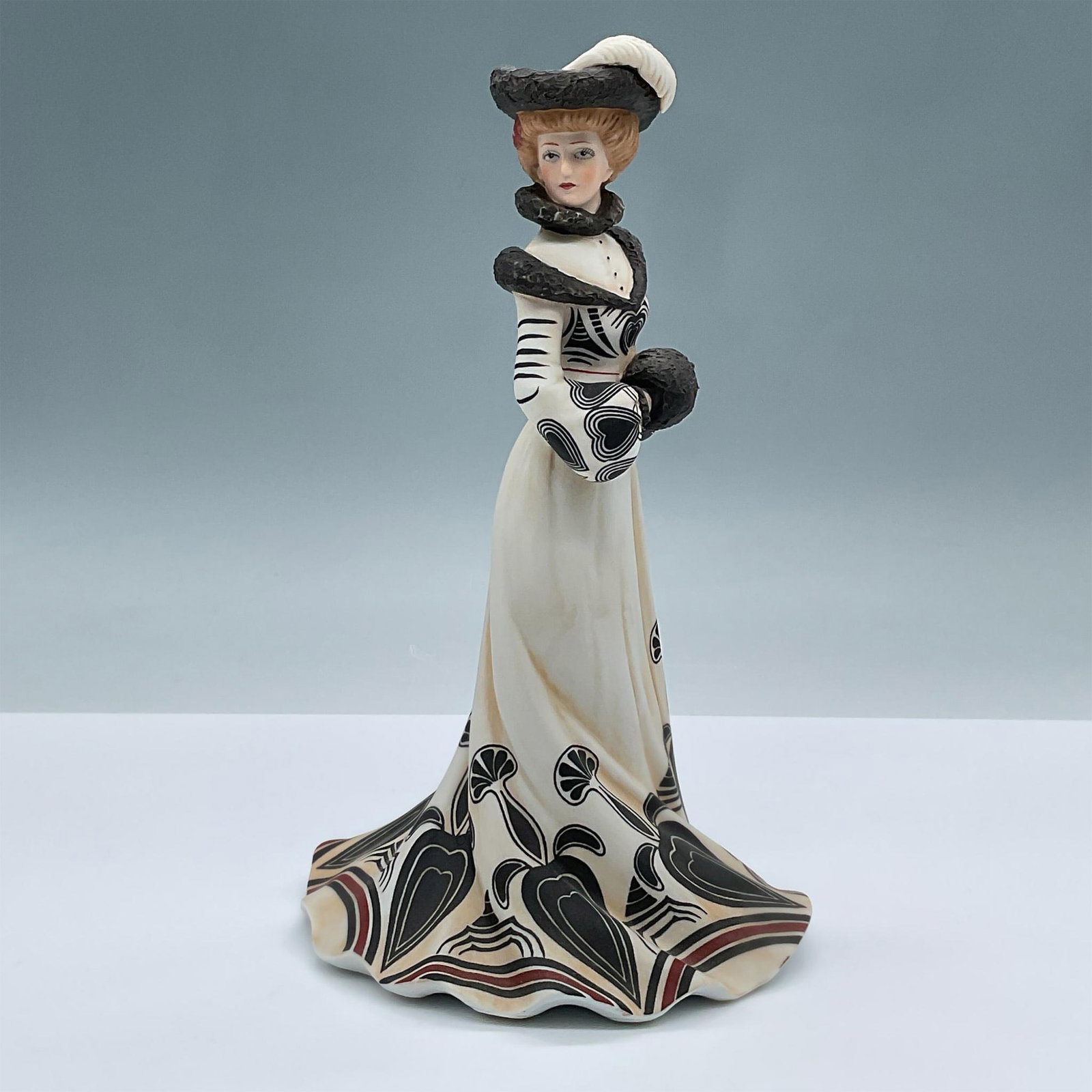 Lenox Fine Porcelain Figurine, Tea At the Ritz: Features a gorgeous porcelain figure of a woman fashioned in a black and white dress with a heart shaped pattern and red details. Lenox backstamp. Issued: 20th century Dimensions: 5"L x 4.5"W x 8.75"H