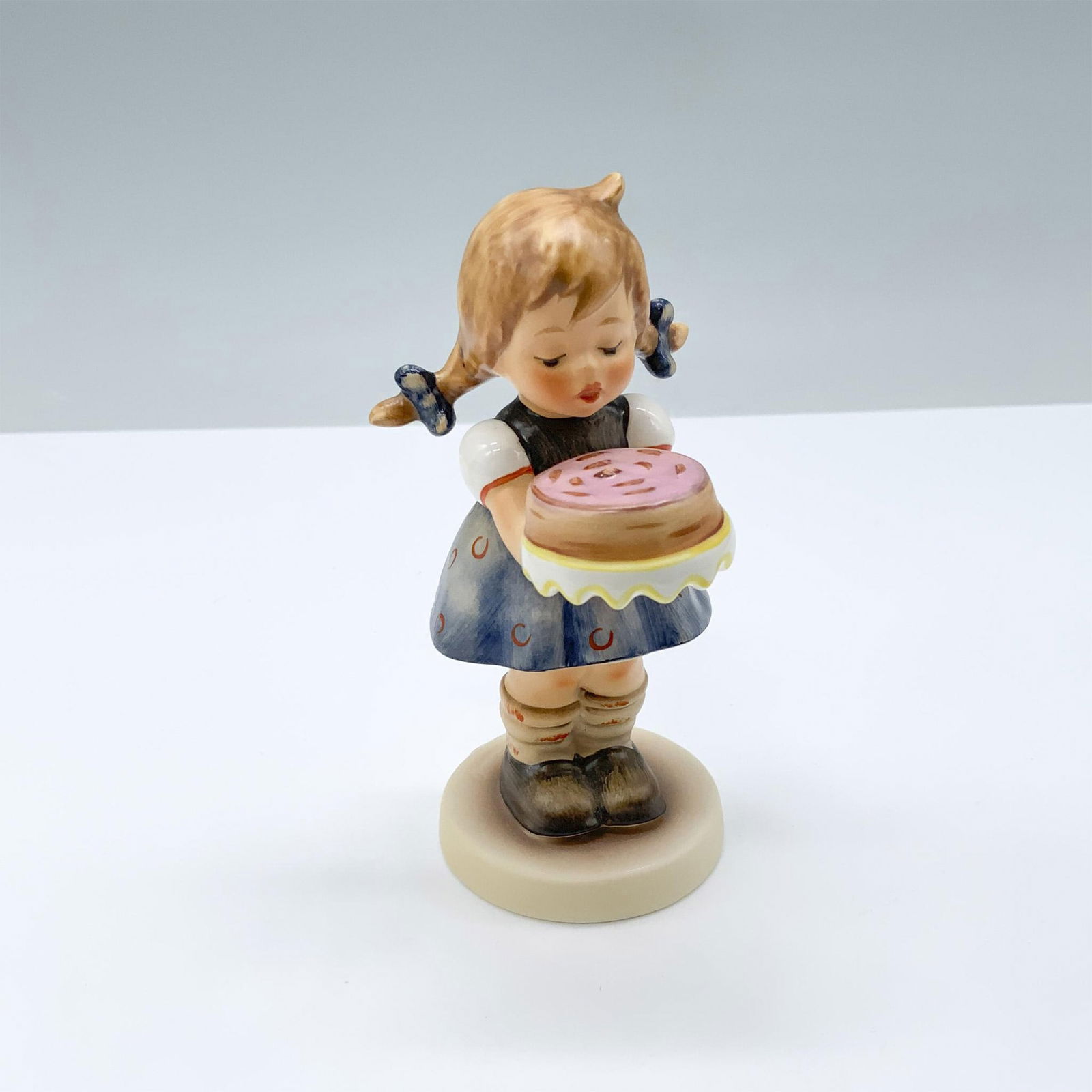 Goebel Hummel Porcelain Figurine, Sweet As Can Be: Figure of a girl with pig tails holding a cake. 143/Hum 541. M.I. Hummel impressed. Goebel backstamp.. This item has its original box. Box measures: 5.75"L x 3.5"W x 3.5"H. Dimensions: 2.5"L x 2"W x 4