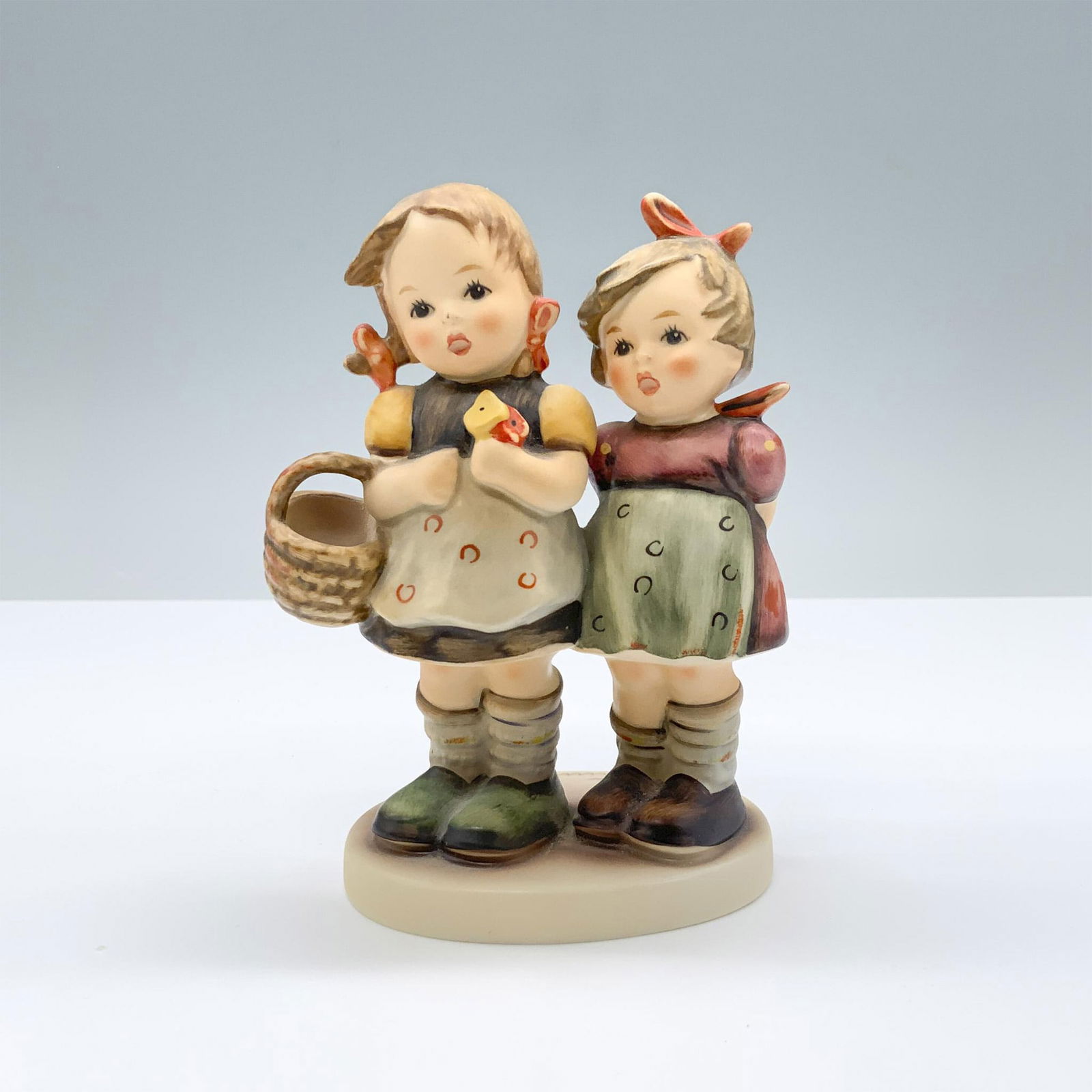 Goebel Hummel Porcelain Figurine, Daddy's Girls: Hand painted figure of sisters. M.I. Hummel impressed. Goebel backstamp. 753/Hum 371. This item has its original box. Box measures:: 7"L x 5.25"W x 3.5"H. Dimensions: 3.5"L x 2.25"W x 4.75"H Manufactu