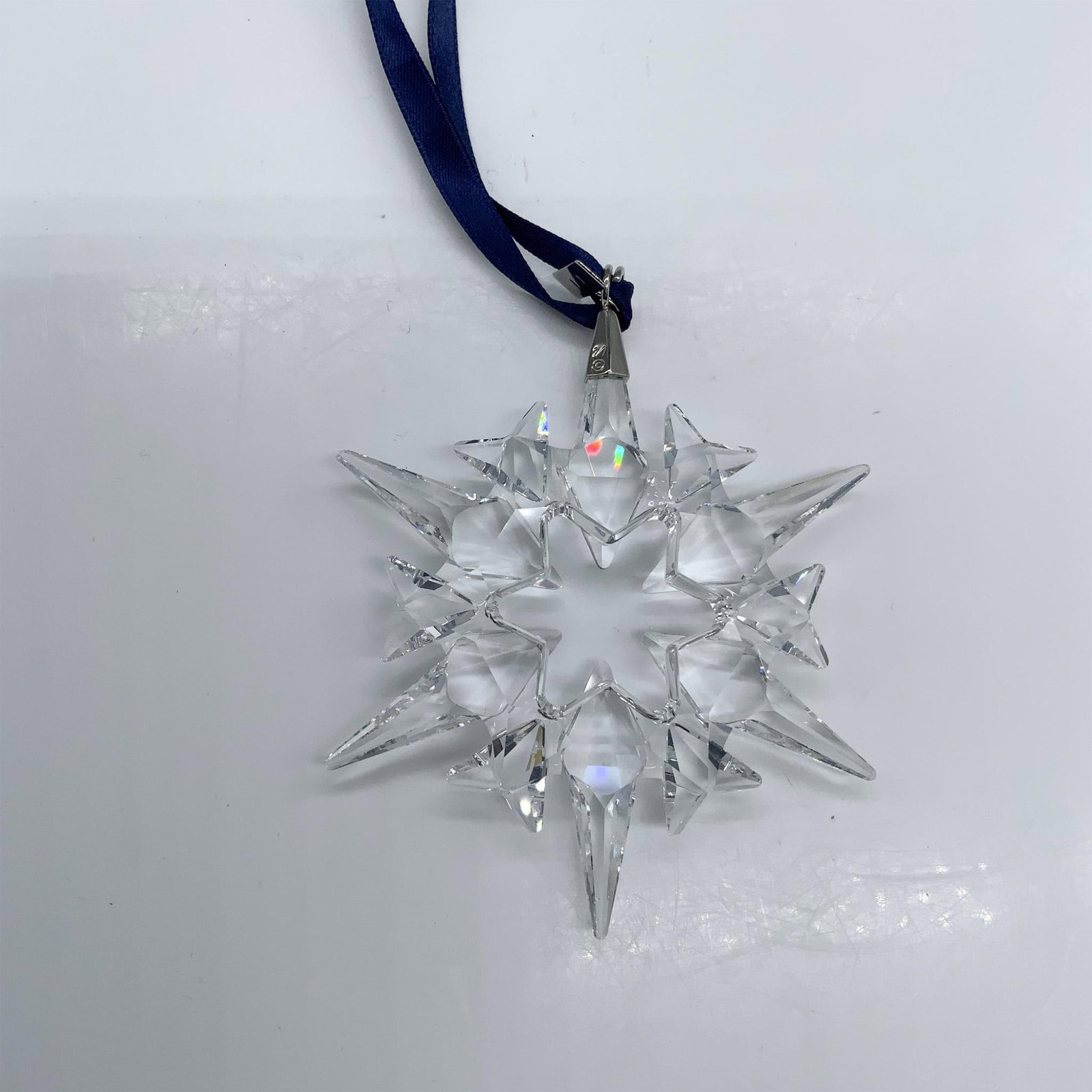 Swarovski Crystal 2007 Christmas Ornament 872200: This beautiful Christmas ornament was crafted from faceted clear crystal with silver metal and a blue ribbon. Swarovski hallmark. The triangular box measures 5.75"L x 6.5"W x 1.25"H. Artist: Eva Maria