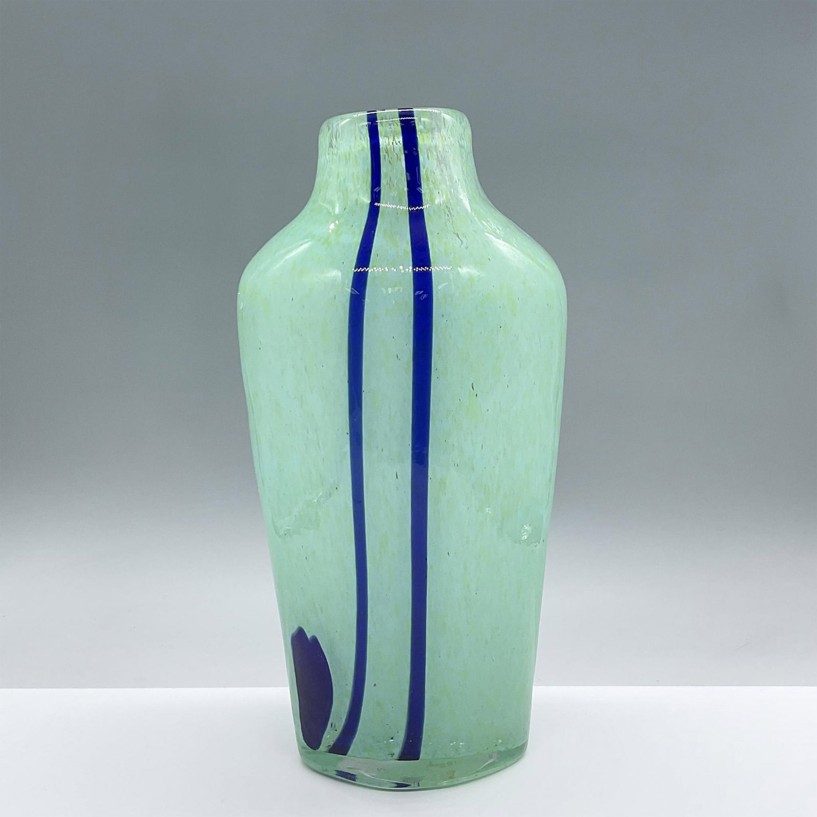Contemporary Green Glass Art Vase: This enchanting mint green vase includes two blue vertical striped lines and a blue blotch. Issued: 21st century Dimensions: 6"L x 4"W x 11.5"H