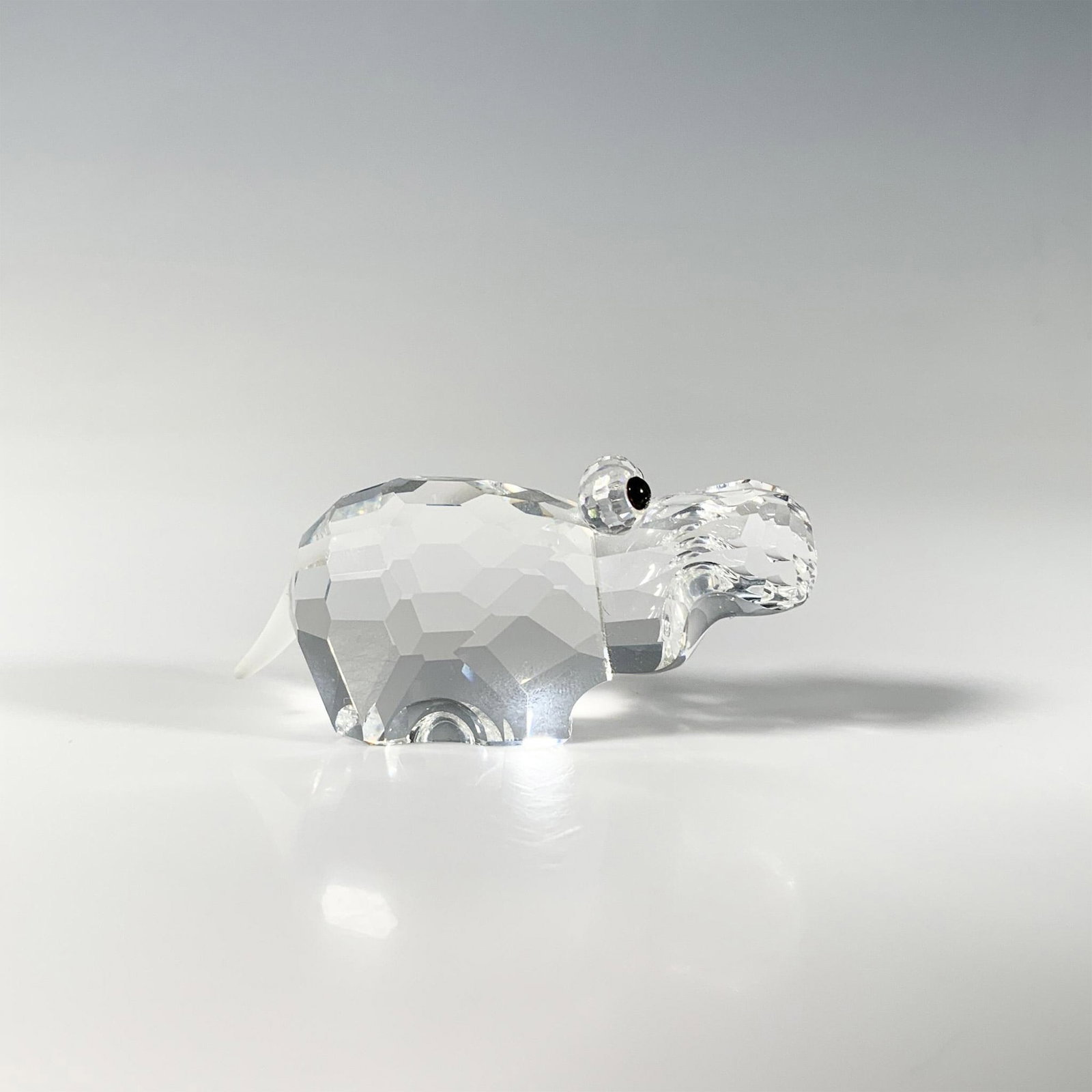 Swarovski Crystal Figurine, Hippopotamus: A cute hippo crafted from cut crystal, featuring a frosted tail and smooth black eyes. Part of the African Wildlife series. Swarovski acid mark. This item has its original box: 3.25"W x 2.5"H. Artist: