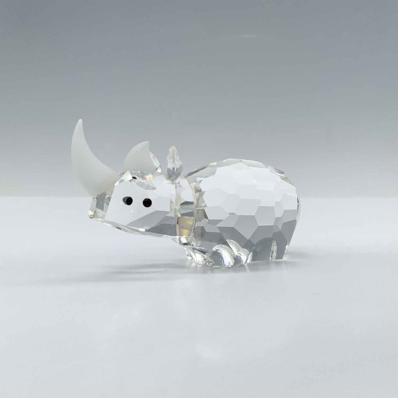 Swarovski Crystal Figurine, Small Rhinoceros: Magnificent crystal clear faceted figure with black eyes and frosted horns. This figure was part of the African Wildlife collection. Swarovski backstamp 151521. This item has its original box 4.75"H x