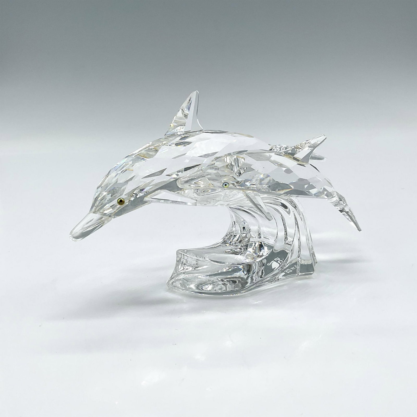 Swarovski Crystal Figurine, Lead Me, The Dolphins: 1st piece in the Mother and Child trilogy. Created from clear crystal with aqua crystal eyes. Swarovski backstamp. 153850. This item has its original box: 7.5"H x 7.25" dia. Artist: Michael Stamey Iss