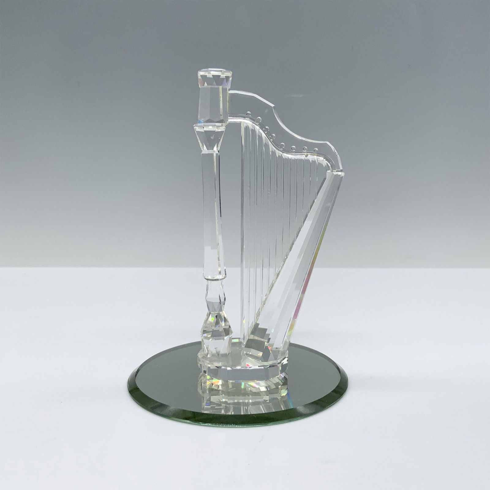 Swarovski Crystal Figurine, Harp: Stunning crystal clear crystal depiction of the most ethereal instrument, the harp. The strings are created with engravings and the column as well as the head are faceted. This figure was part of the