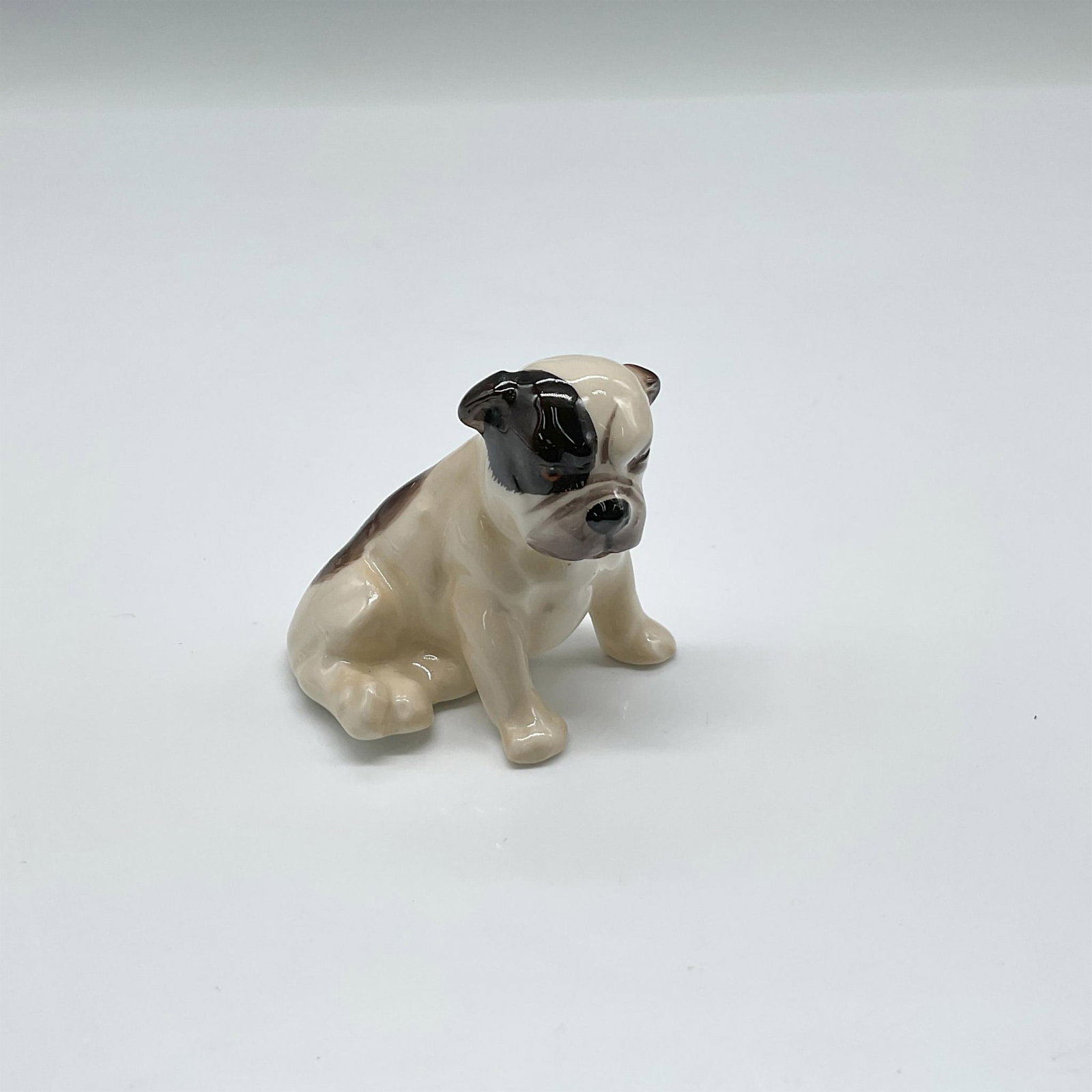 Bulldog Puppy K2 - Royal Doulton Animal Figure: Sitting puppy colored in tan and brown. Royal Doulton backstamp. Issued: 1931 - 1977 Dimensions: 2"L x 1.5"W x 2"H Manufacturer: Royal Doulton Country of Origin: England