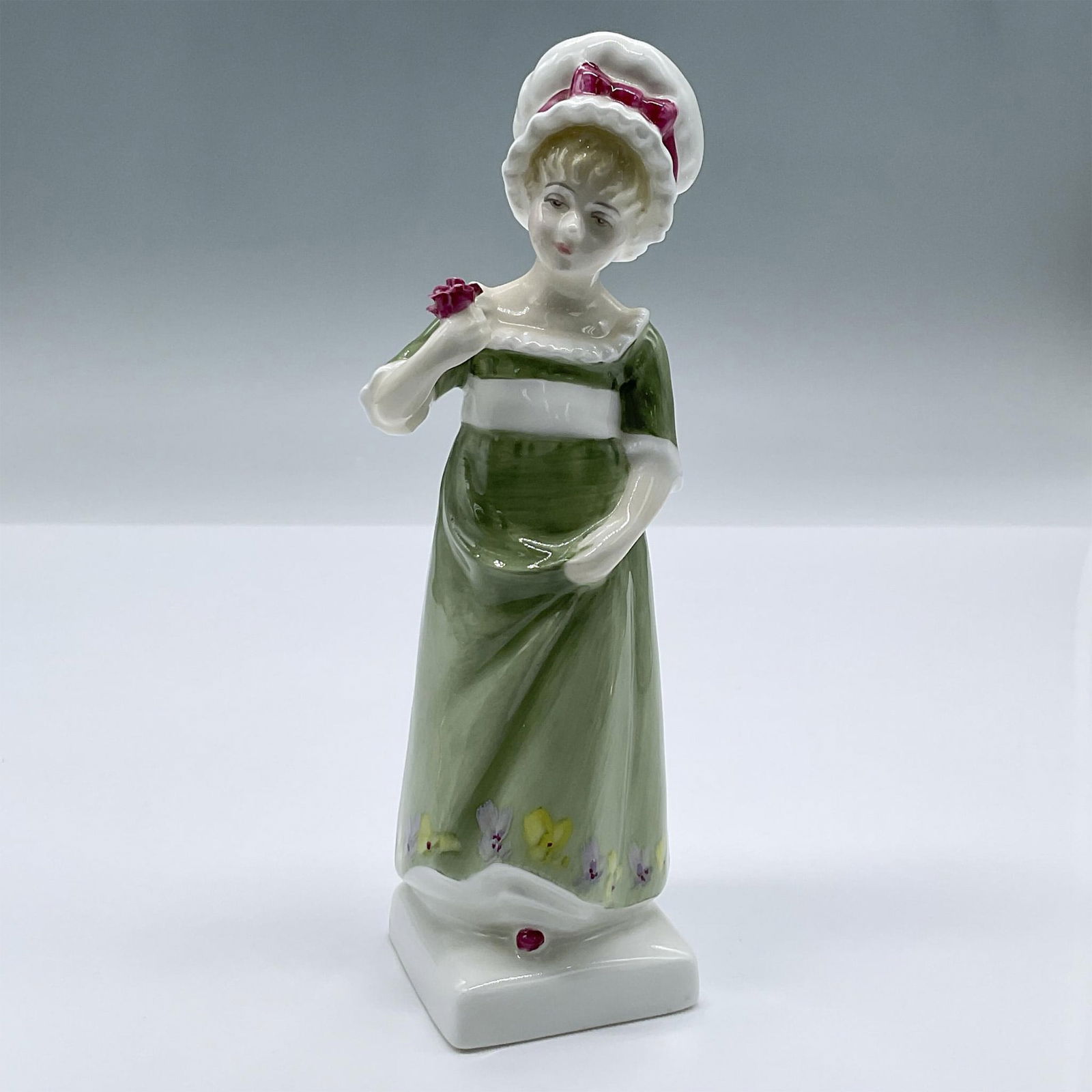 Ruth - HN2799 - Royal Doulton Figurine: Part of the Kate Greenaway series. Features a young girl in a green dress with a rose in one hand. Royal Doulton backstamp. Artist: Peggy Davies Issued: 1976 - 1981 Dimensions: 2"L x 2"W x 6.5"H Manuf