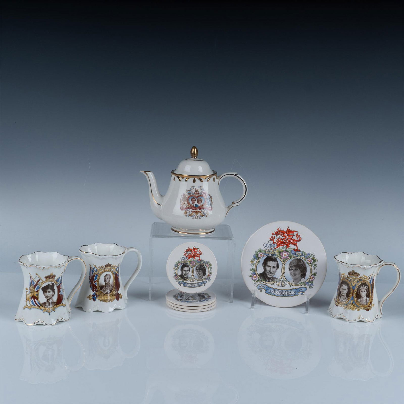 9pc British Royalty Commemorative Tea Pot and Mugs: Collection includes a lidded tea pot featuring Charles and Diana. They are also featured on four coasters and a tea pot trivet. The other three mugs feature Elizabeth, Edward, and George with Elizabet